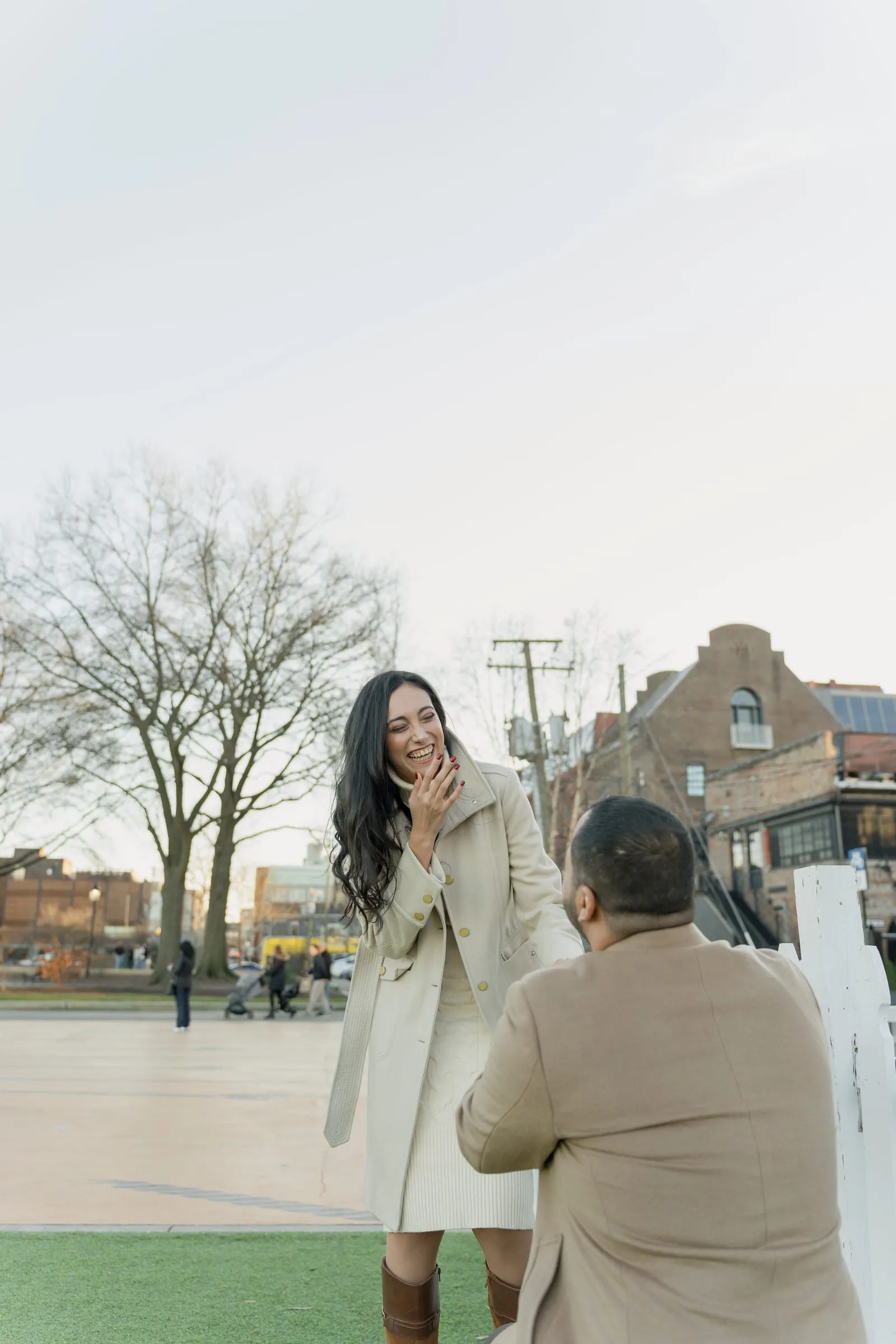 Merona laughing behind one hand as Abanoub kneels on the lawn