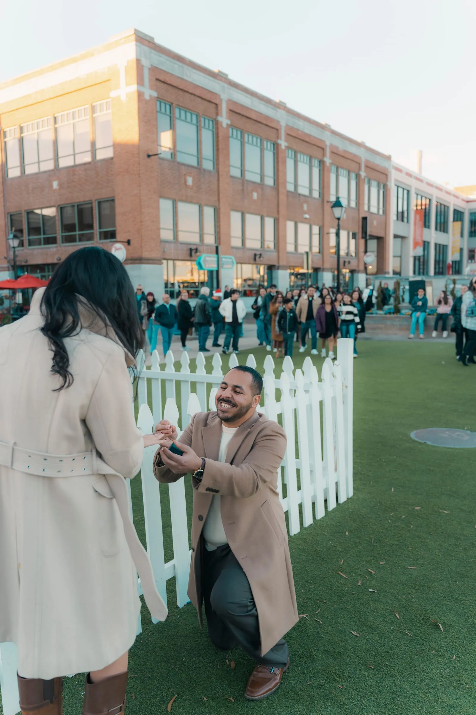 Abanoub slipping the ring onto Merona's finger as a crowd gathers on the Old Town waterfront