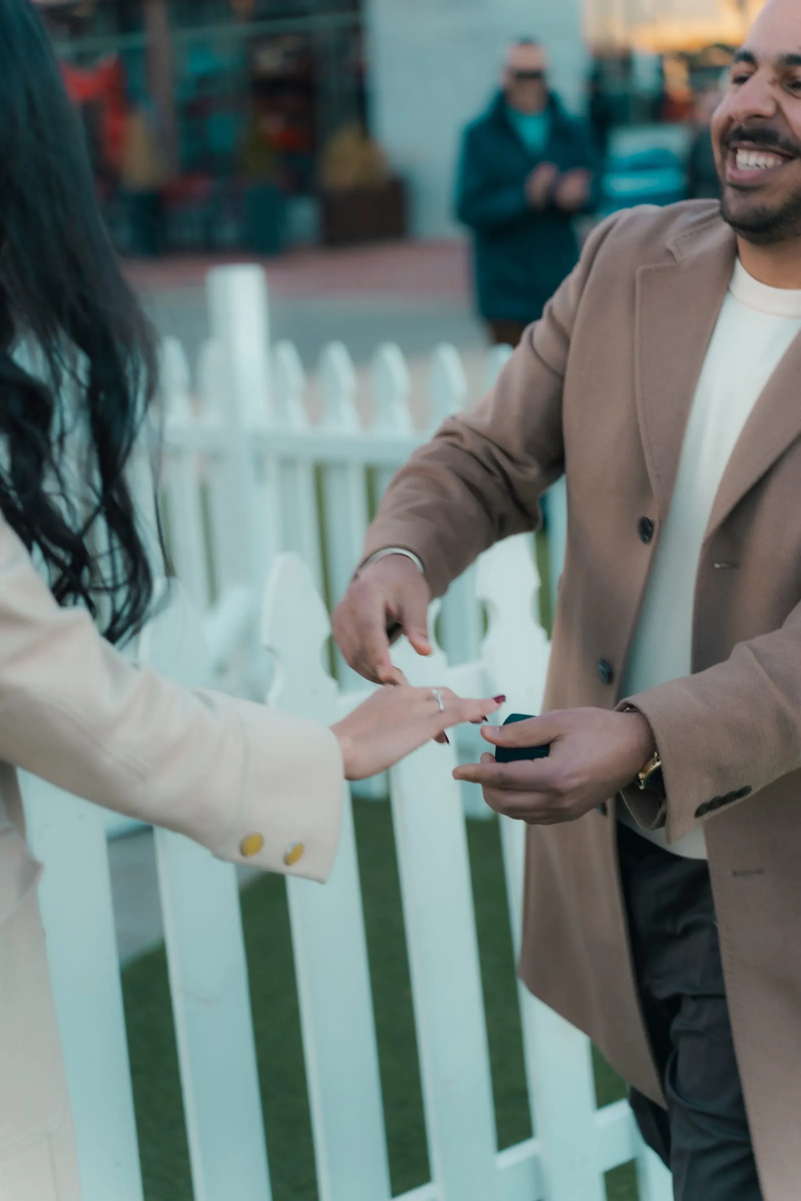 Close-up of Abanoub sliding the engagement ring onto Merona's finger