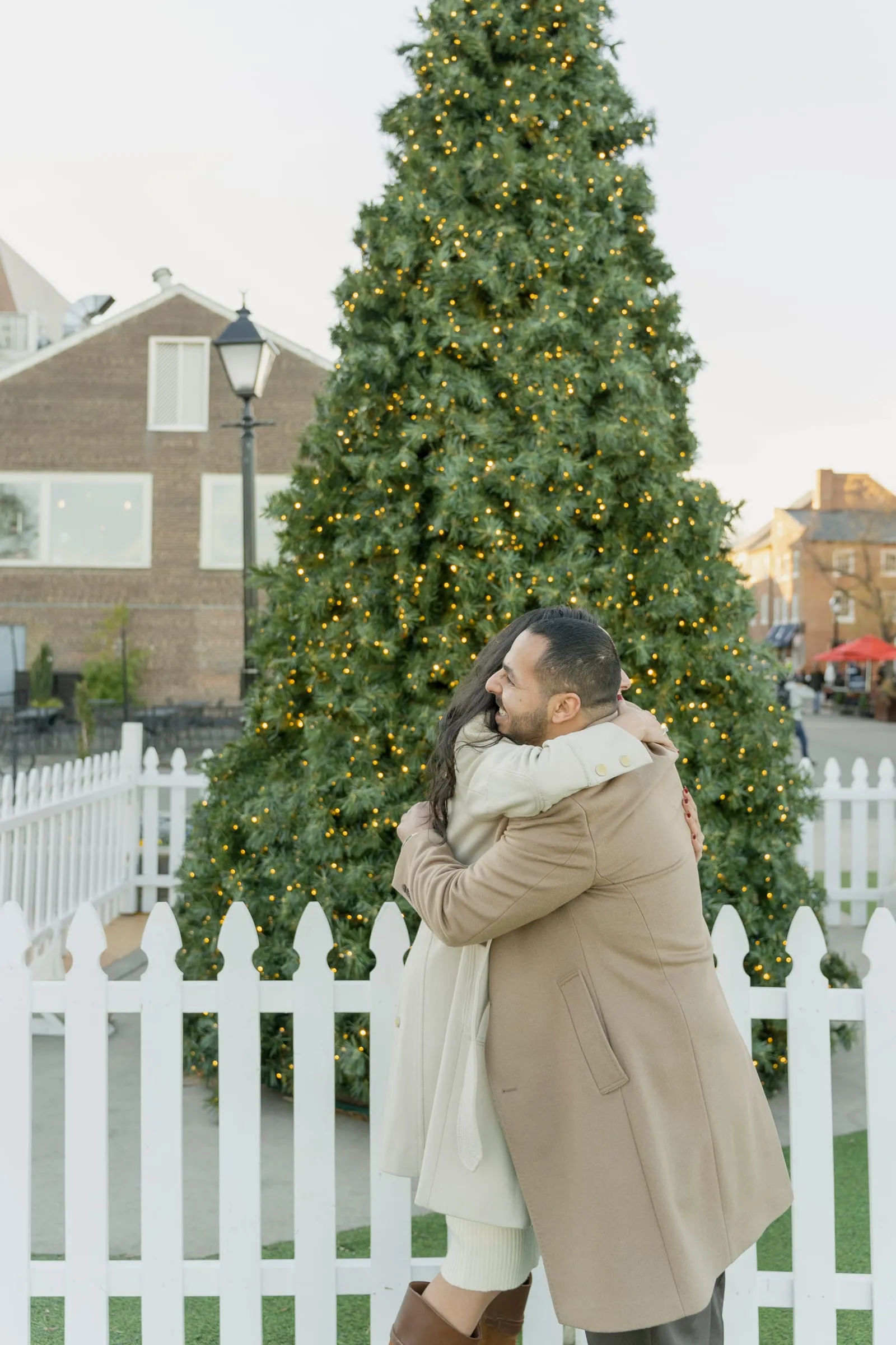 Merona throwing both arms around Abanoub in front of the Christmas tree after saying yes
