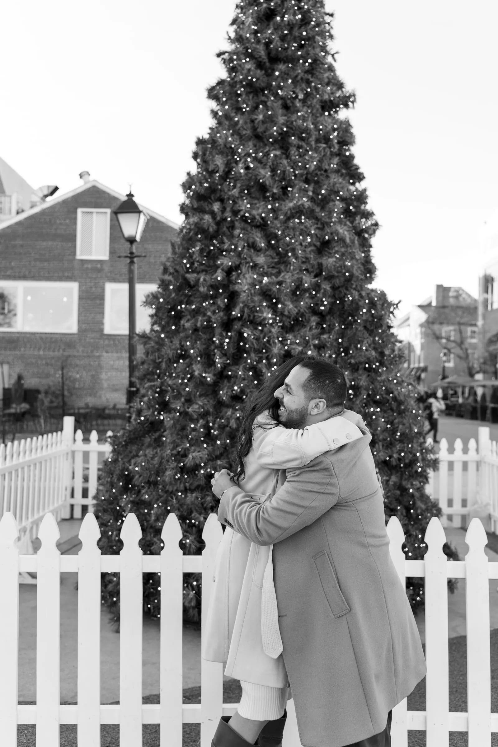 Black and white photo of Abanoub and Merona embracing beside the Christmas tree