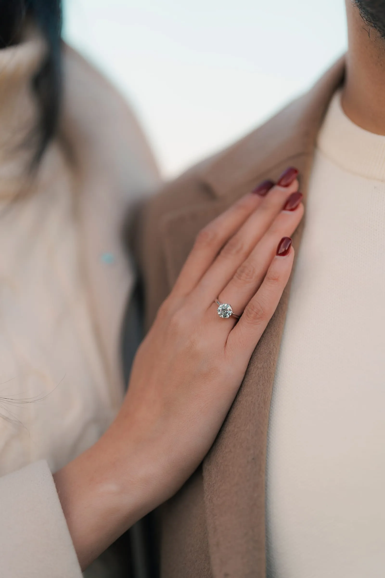 Close-up of Merona's engagement ring on a hand resting against Abanoub's chest