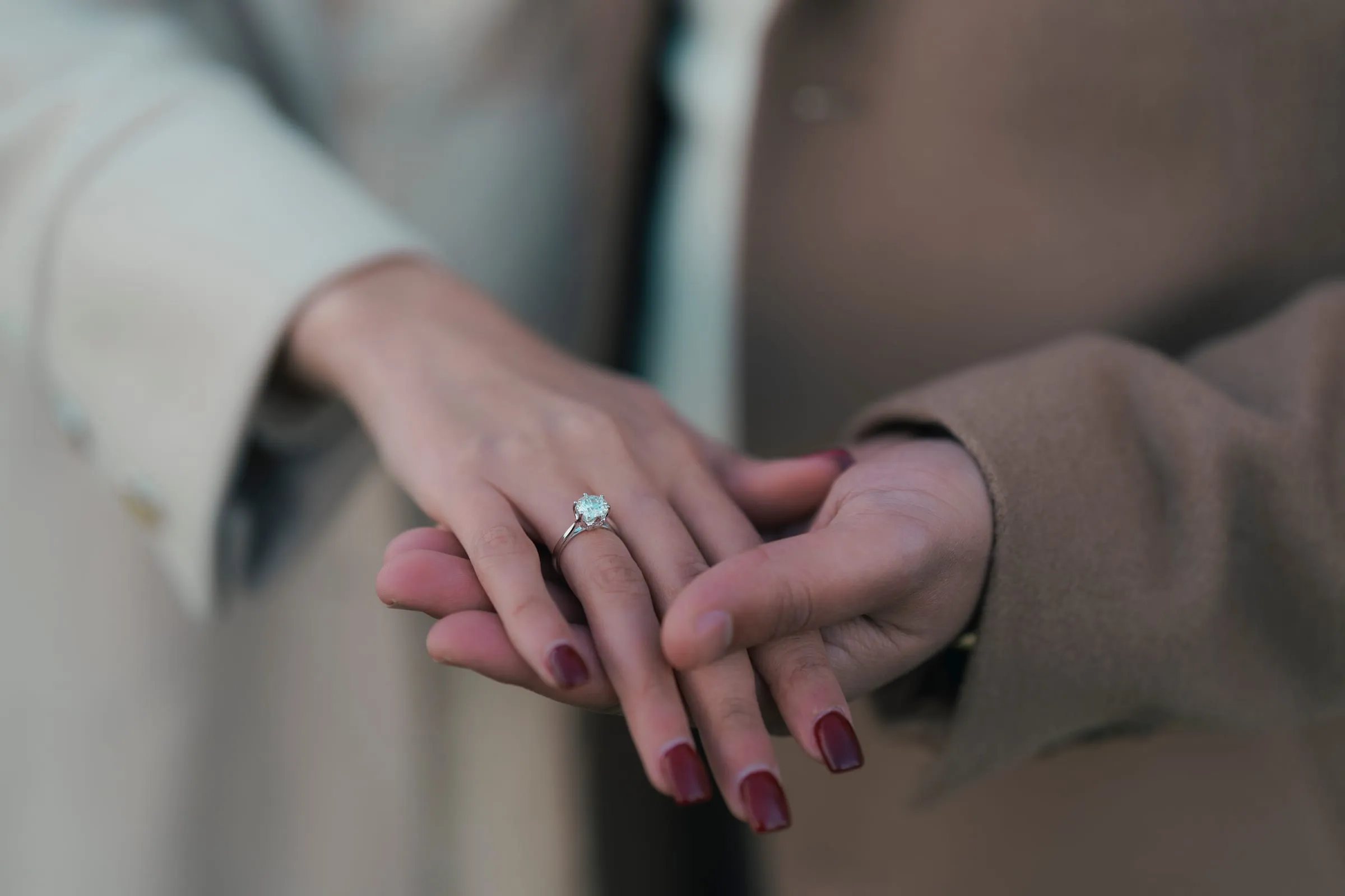 A close crop of Abanoub and Merona's hands together, the diamond ring in focus