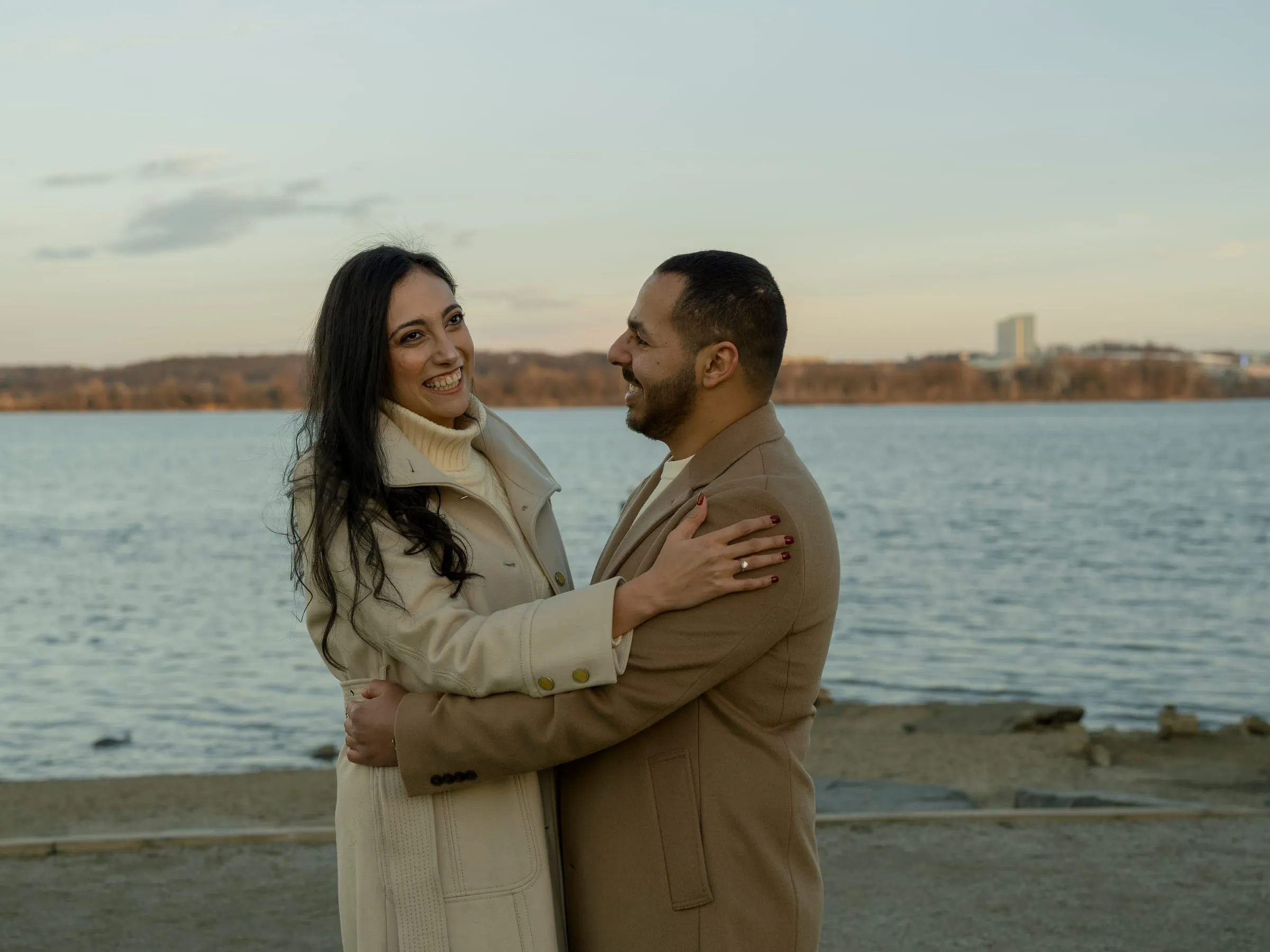 Abanoub and Merona in a close embrace on the riverbank at golden hour