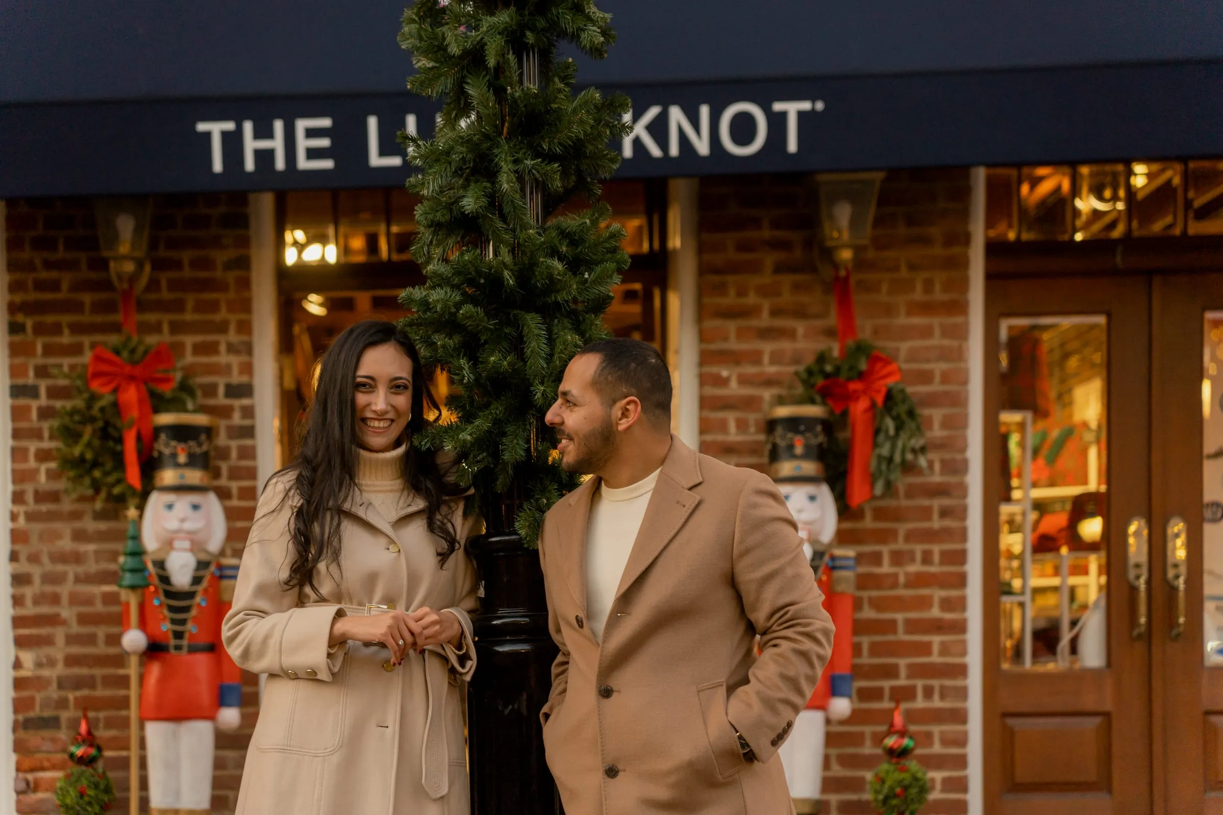 Abanoub and Merona outside a holiday storefront decorated with nutcrackers and red bows