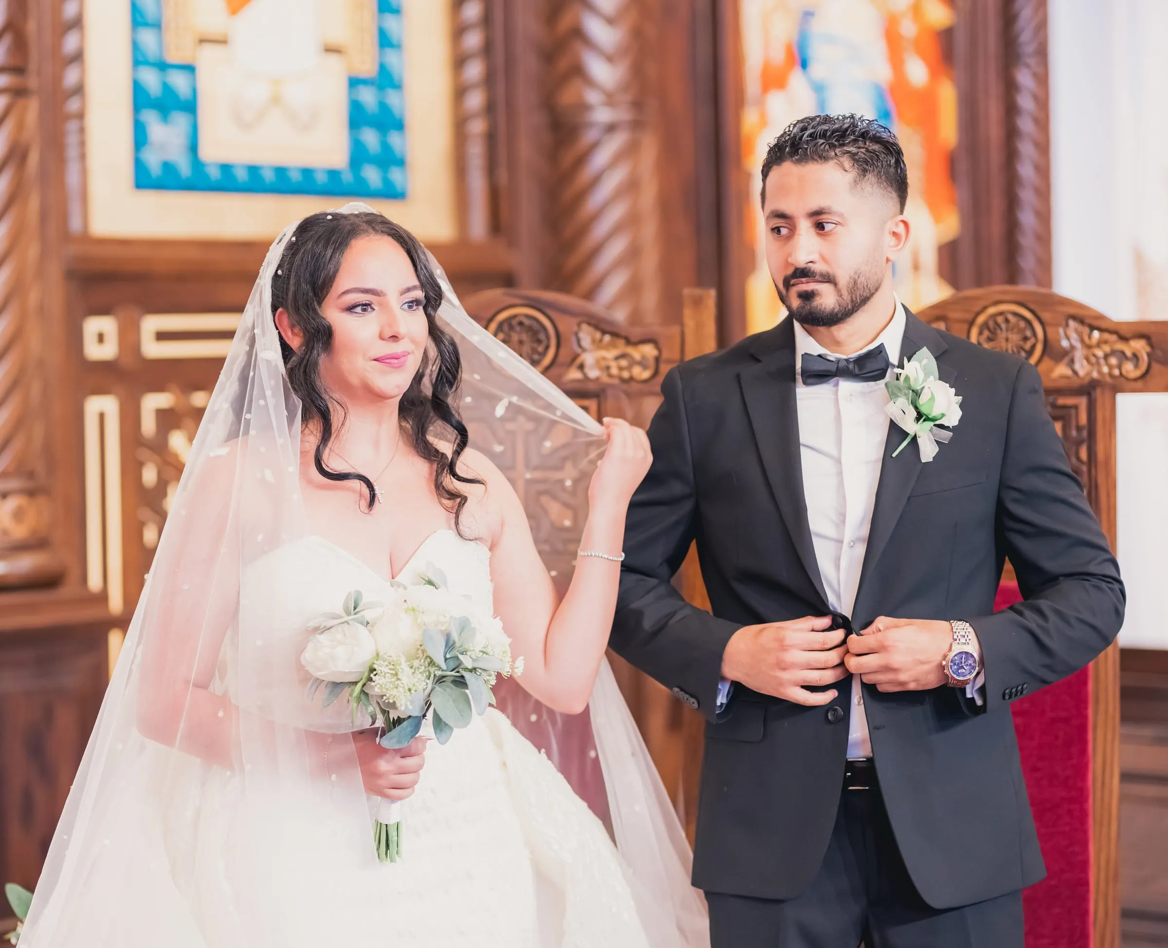 Gina lifting the veil beside Fady at the altar, the church's carved iconostasis behind them