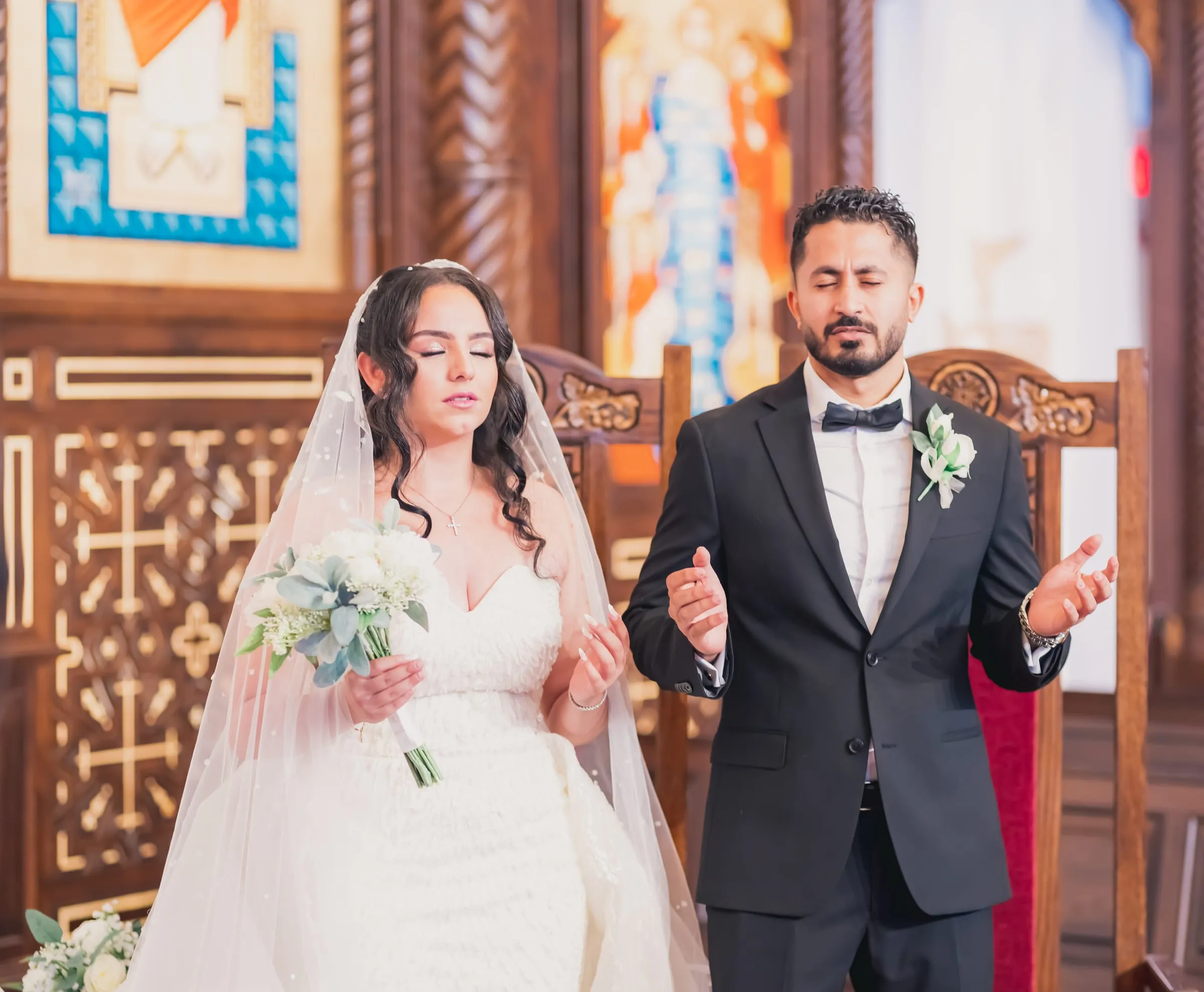 Gina and Fady with eyes closed in prayer during the Coptic wedding service
