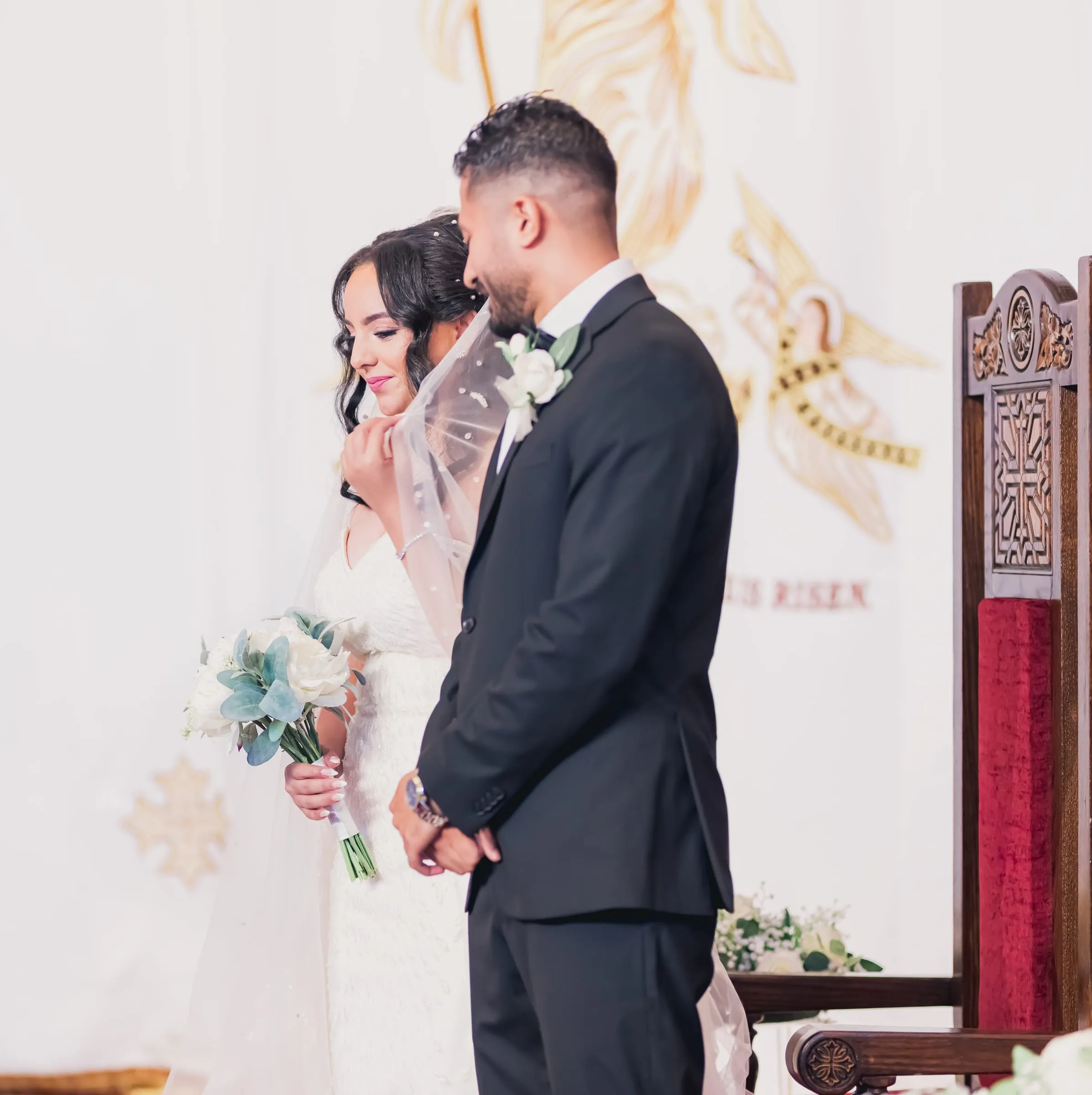 Gina leaning toward Fady as they stand before the altar