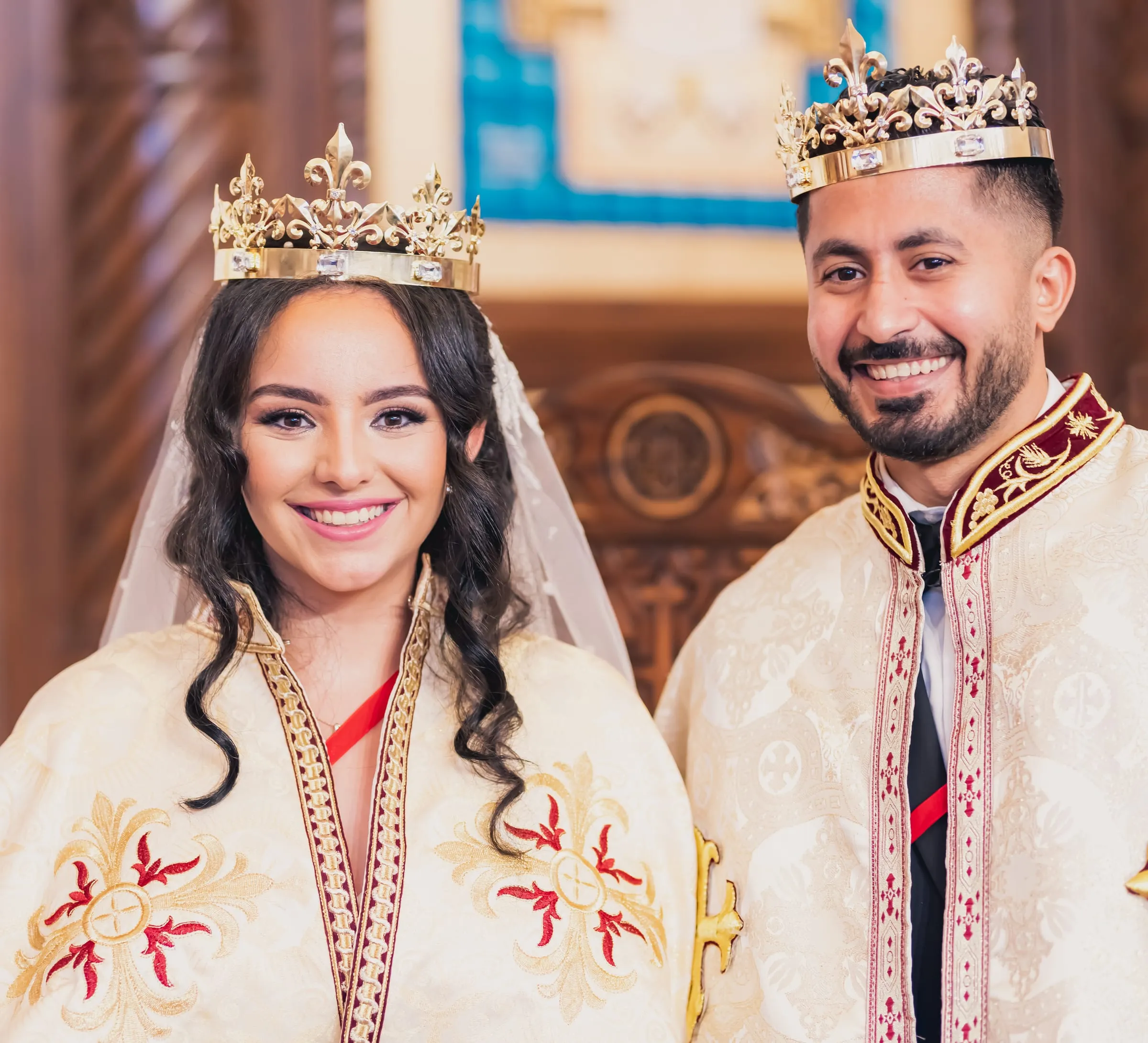 Gina and Fady beaming in their golden crowns and ceremonial robes
