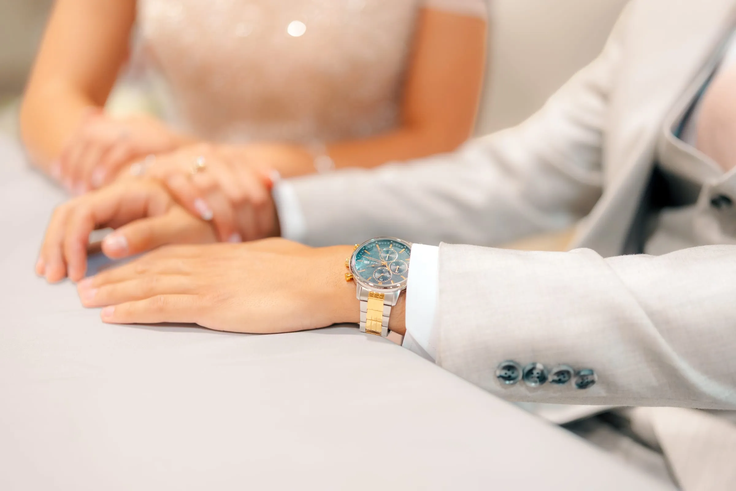 Close-up of Lavina and Youssef's joined hands resting on a table