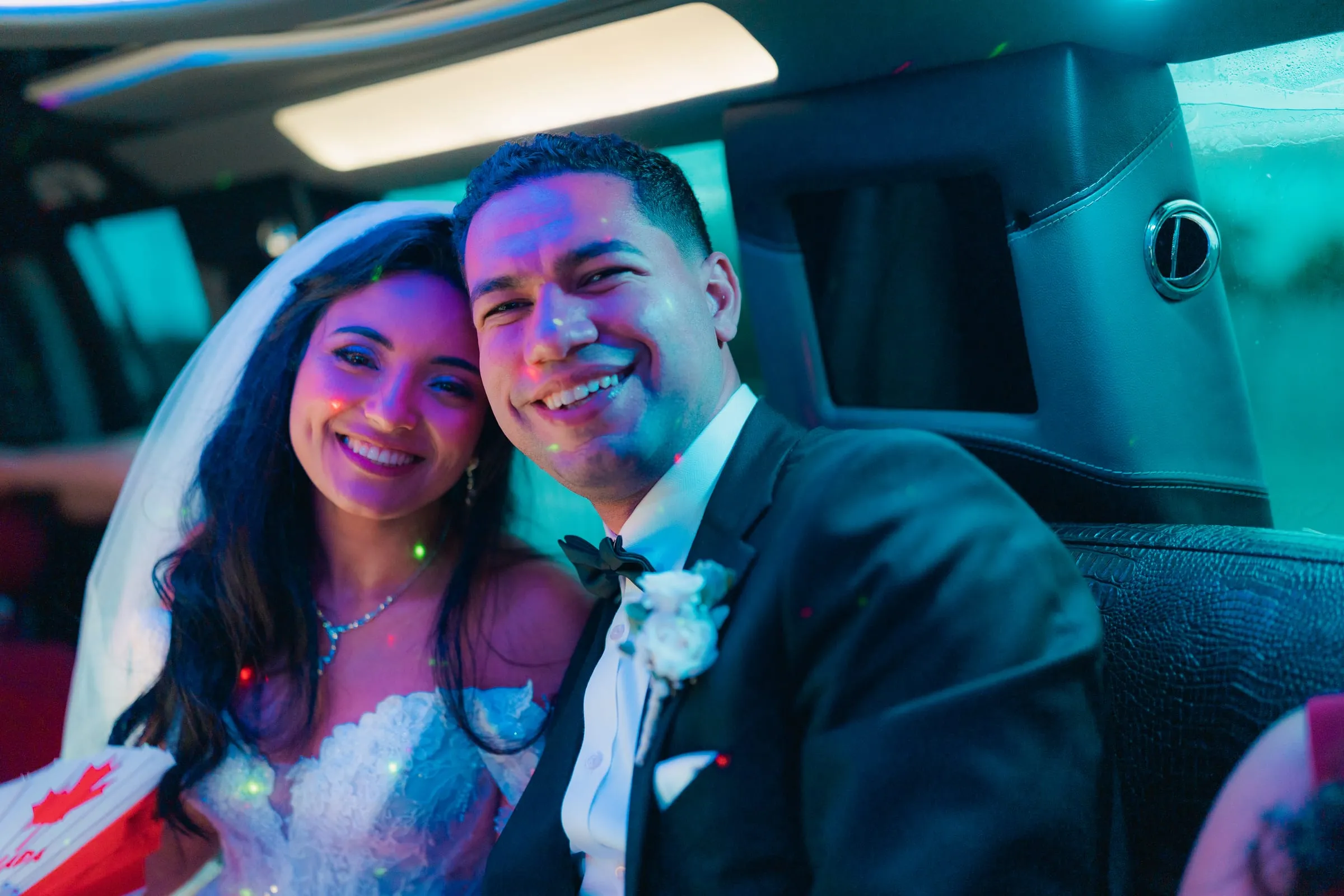 Mariam and Mina smiling cheek to cheek inside the wedding limo