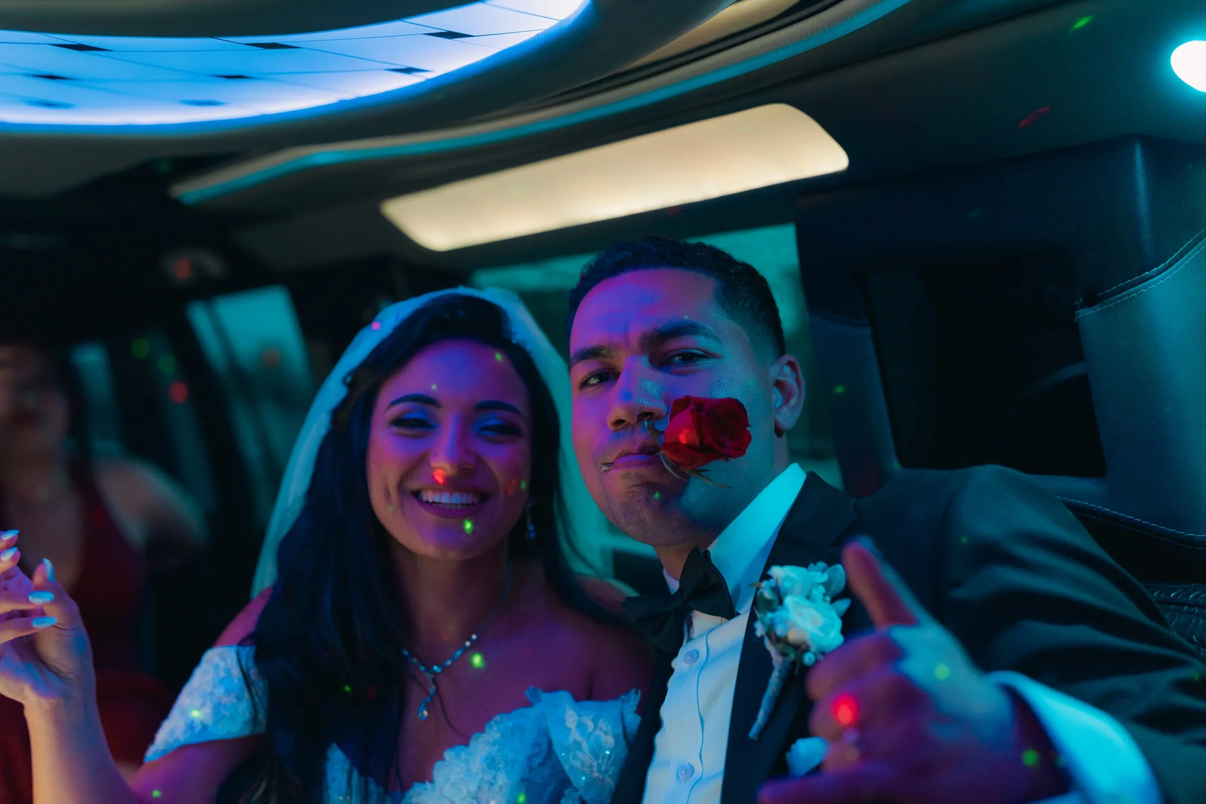 Mariam and Mina laughing inside the limo, Mina holding a rose between his teeth