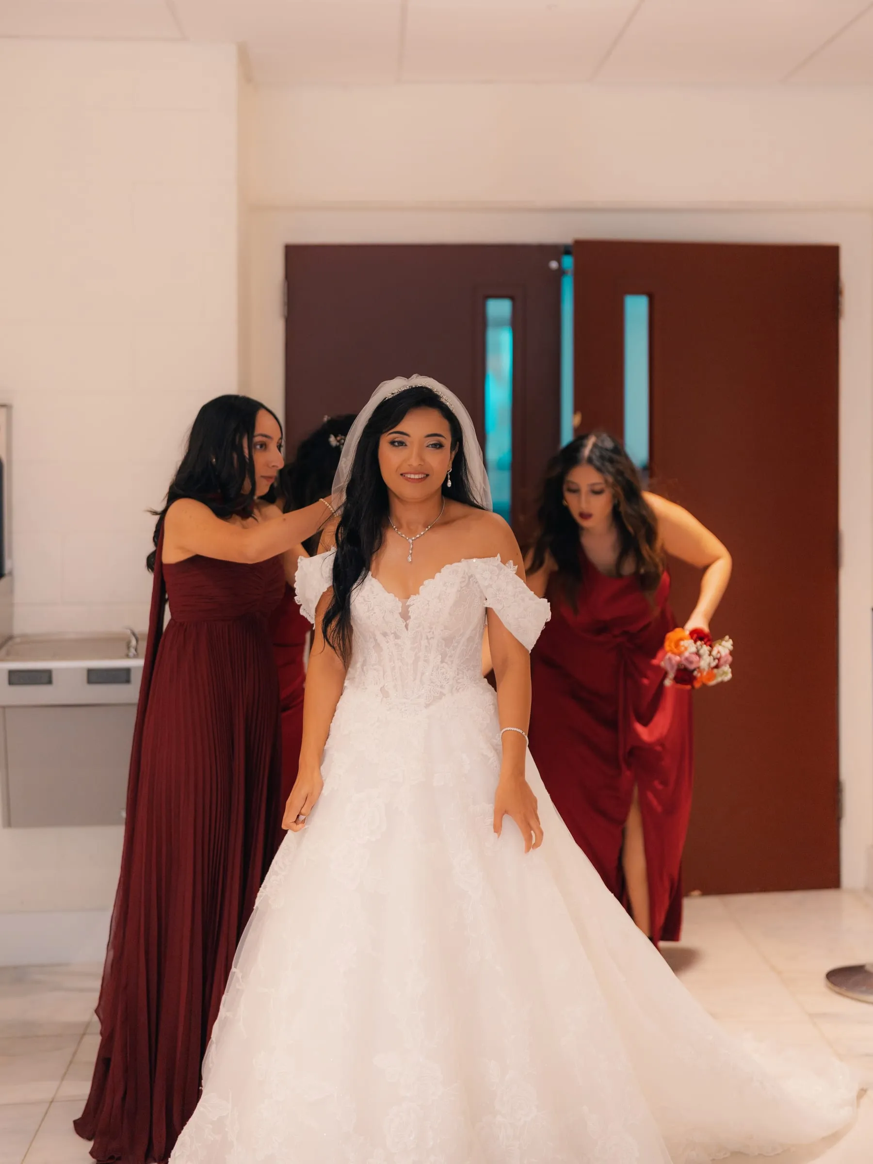 Mariam's bridesmaids adjusting her veil and dress before the ceremony