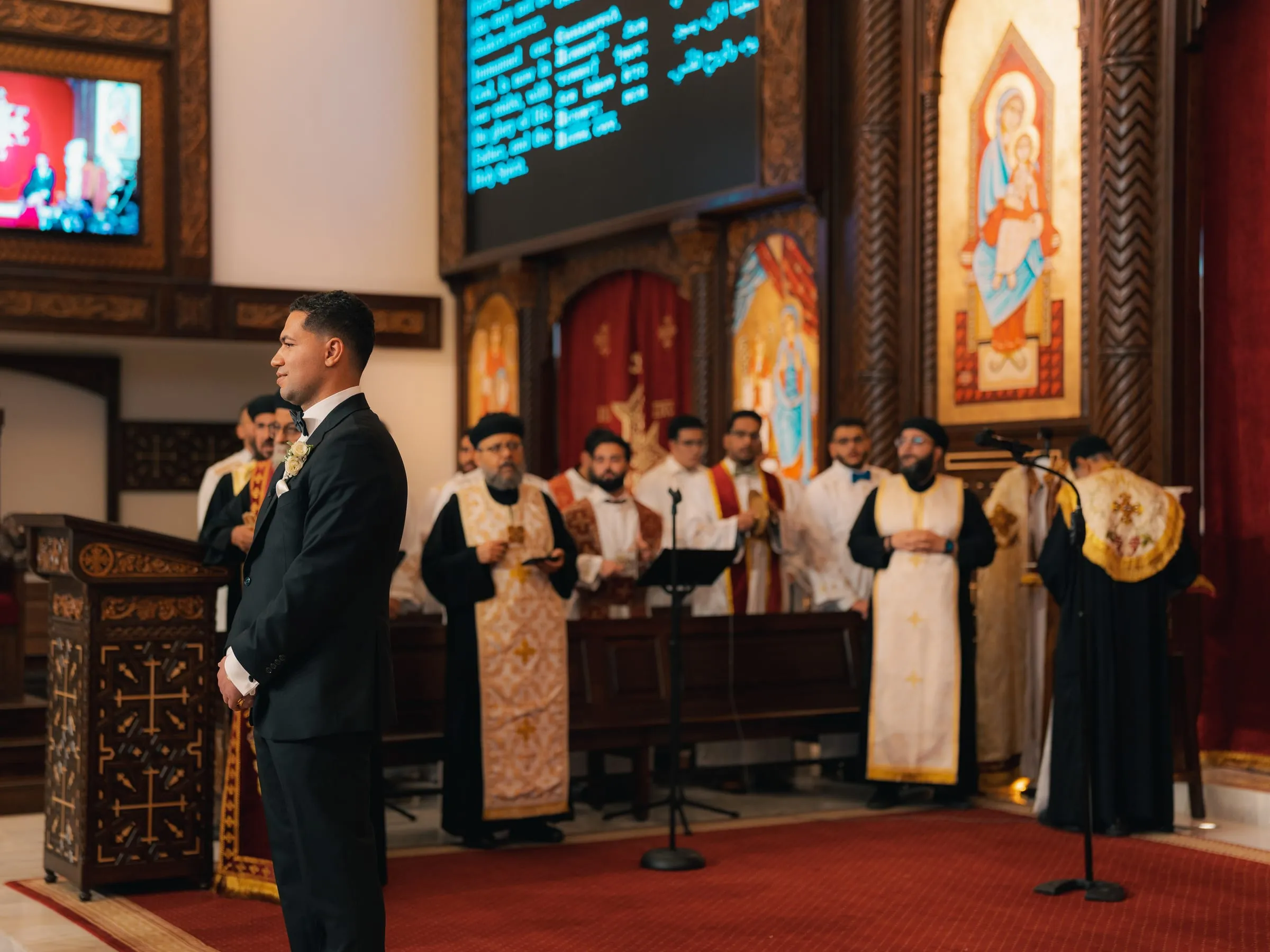 The clergy in vestments conducting Mariam and Mina's wedding ceremony beneath the church's carved iconostasis