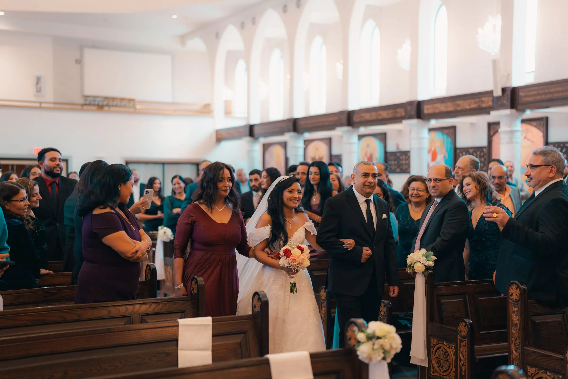 Mariam and her parents processing down the aisle toward the altar
