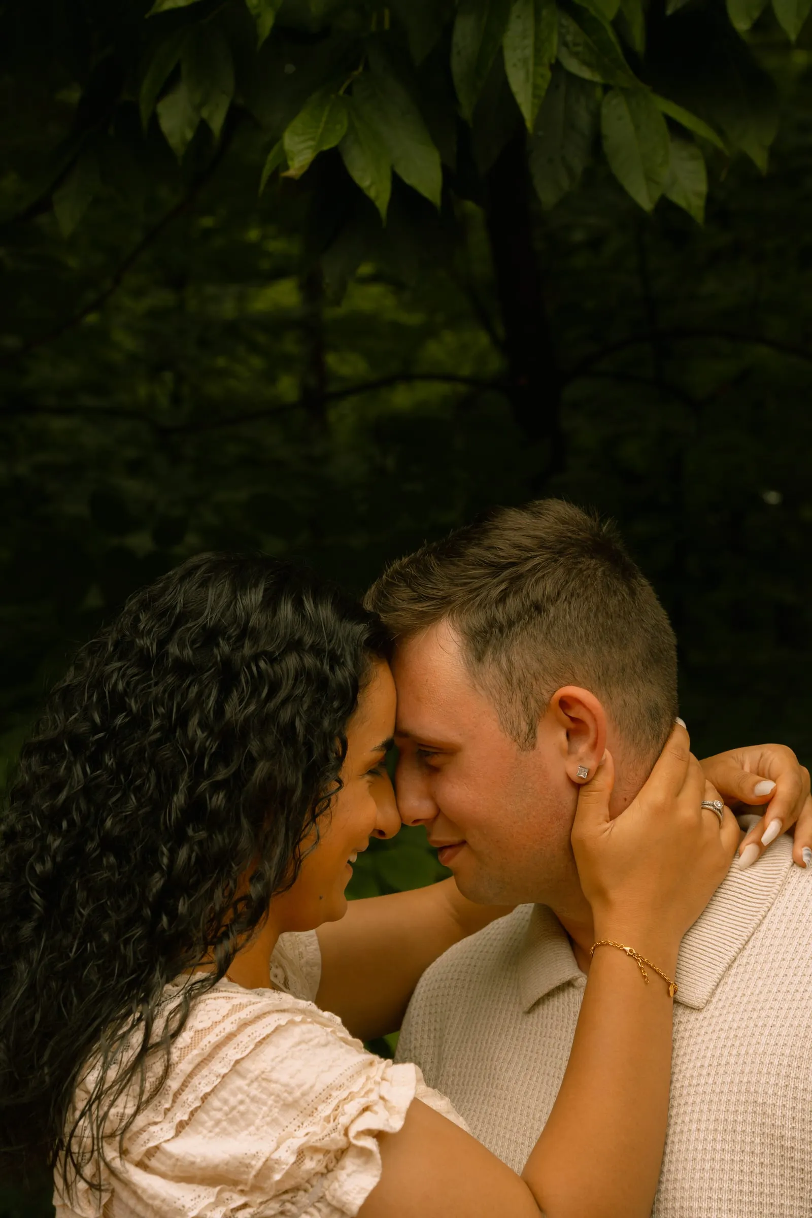 Mariam and Thomas embracing forehead to forehead beneath the trees outside the Westfields Marriott