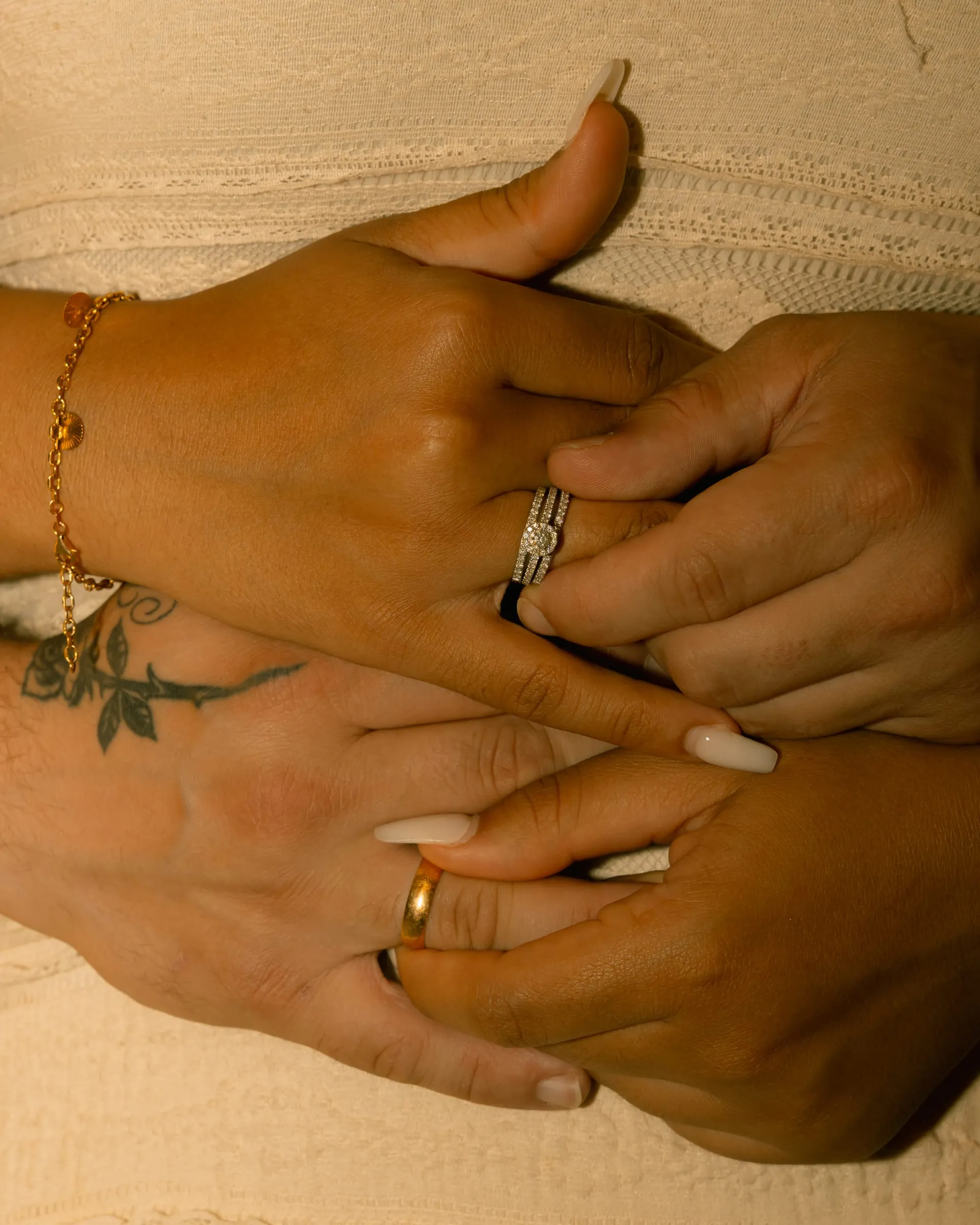 Close-up of Mariam and Thomas's clasped hands showing her engagement ring