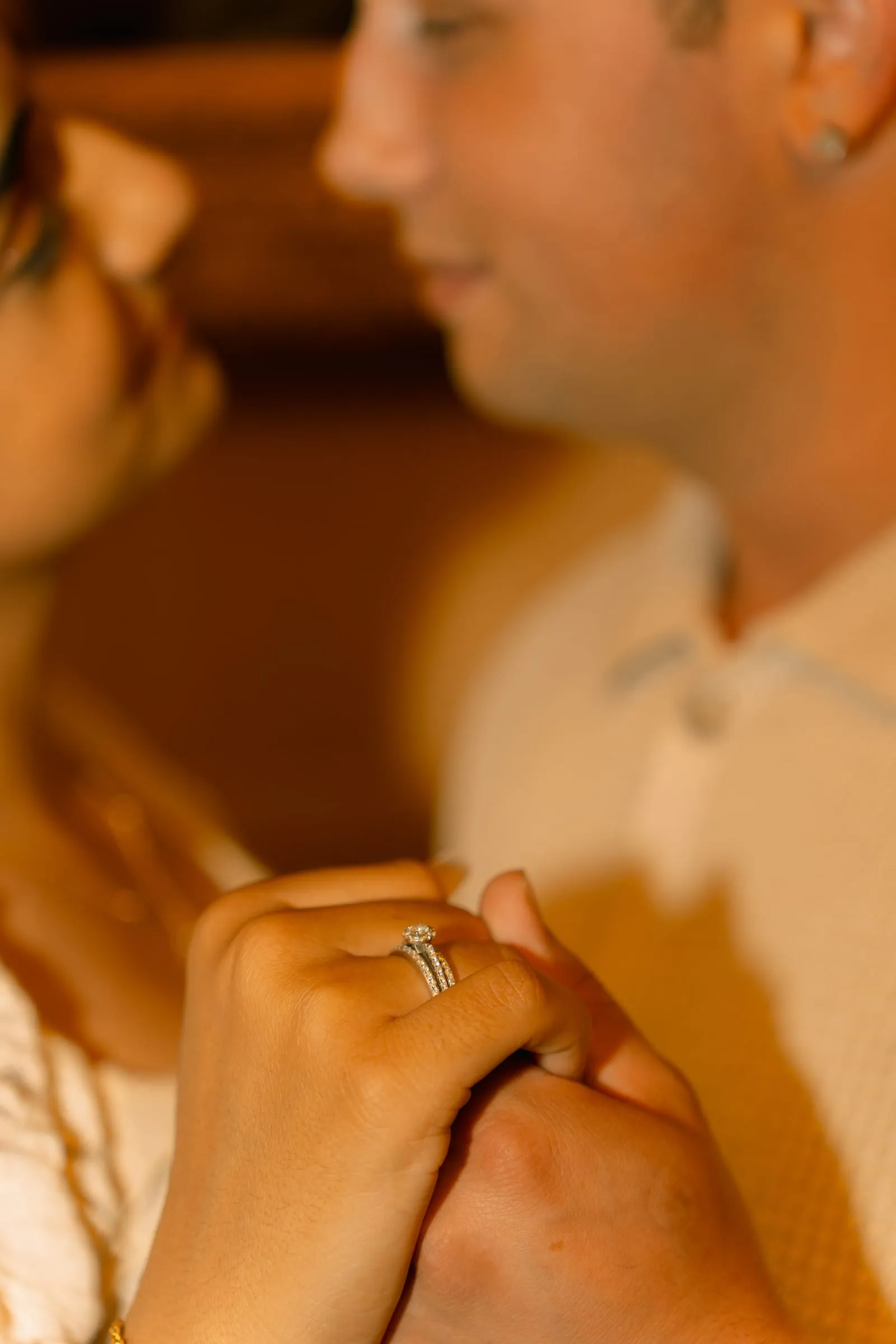 Close-up of Mariam and Thomas's clasped hands with the rest of the scene softly blurred