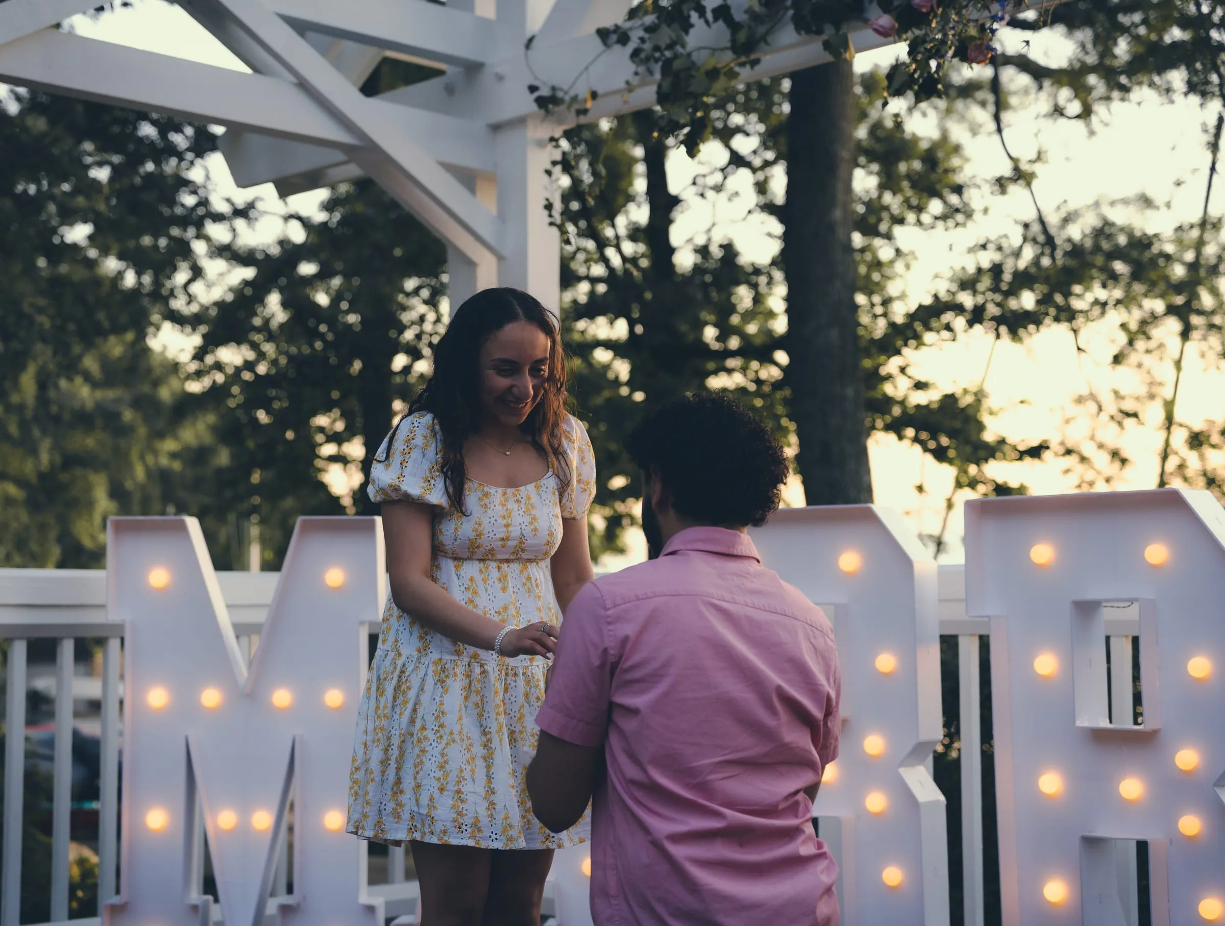 Marina smiling as George slips the ring onto Marina's finger