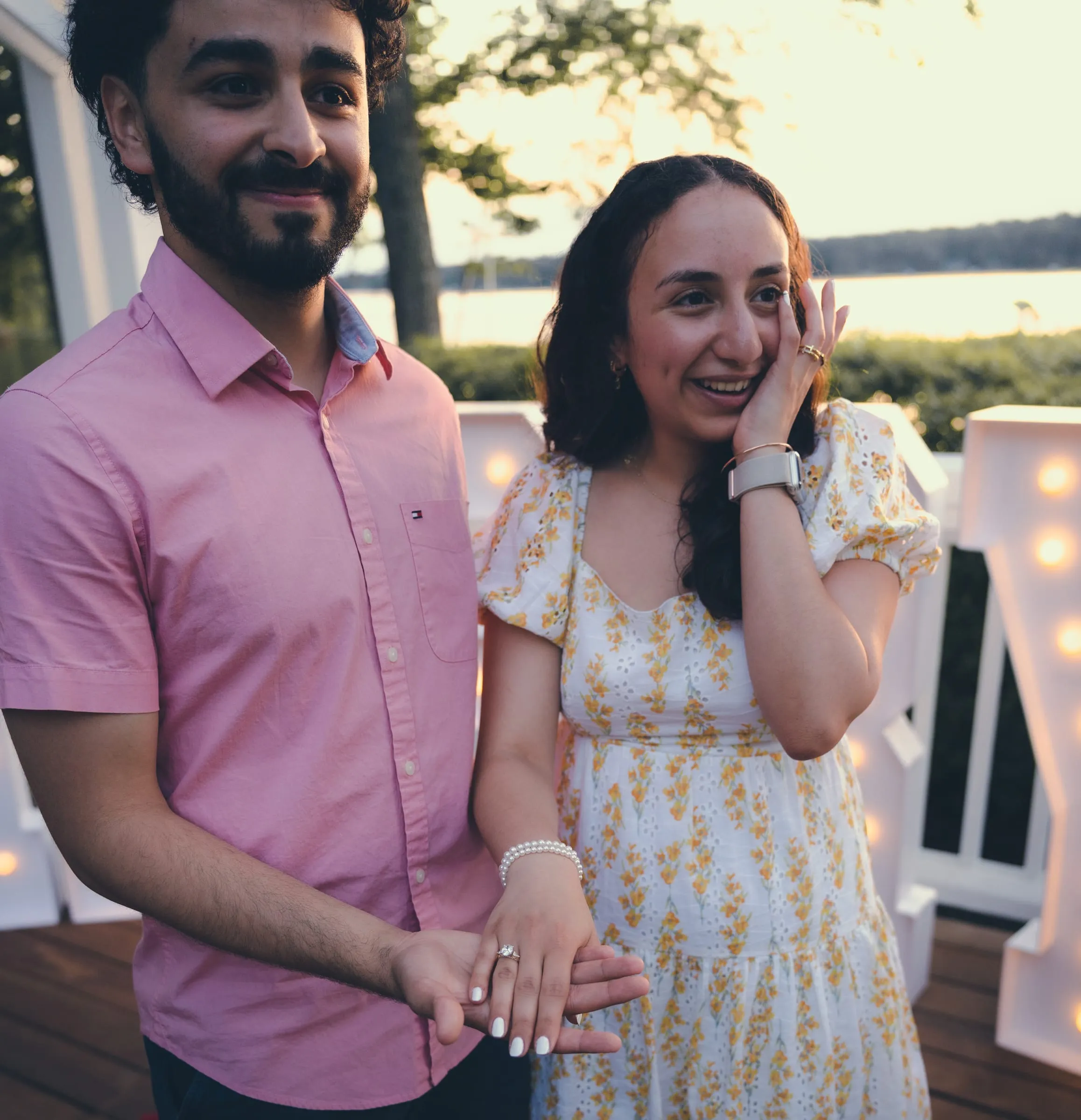 Marina wiping away a happy tear, the new ring on display beside George