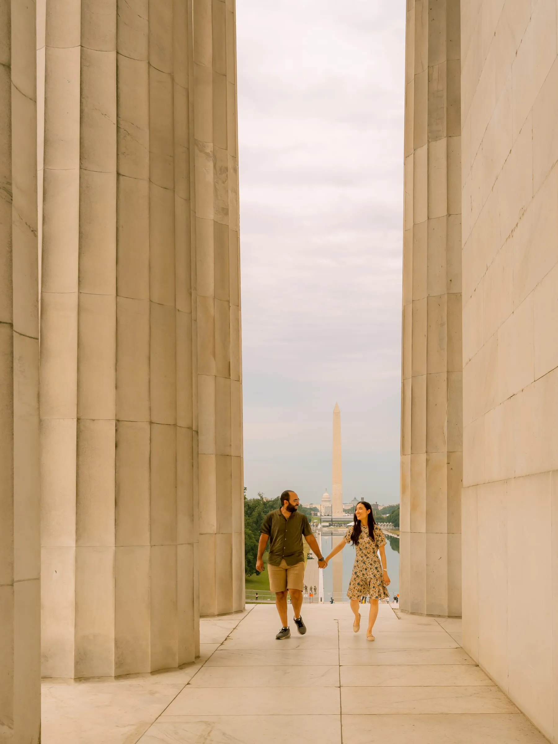 Maryann and Samuel walking hand in hand between the columns of the Lincoln Memorial