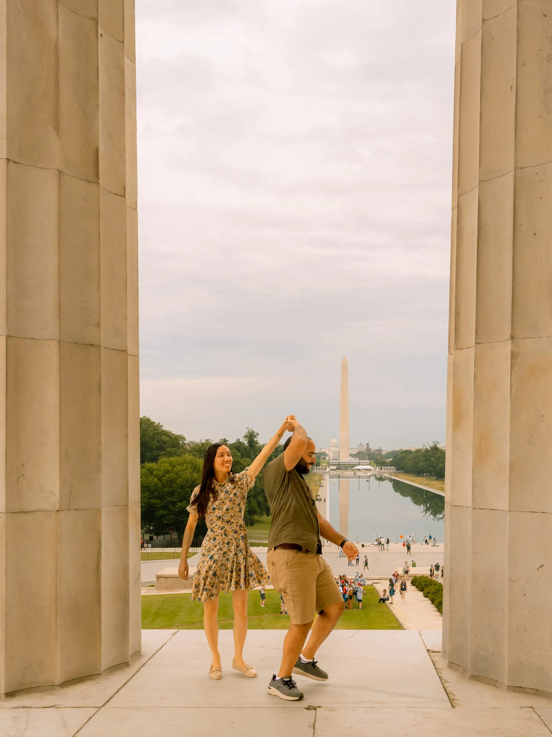 Samuel twirling Maryann as her dress catches the movement, framed by the memorial's columns