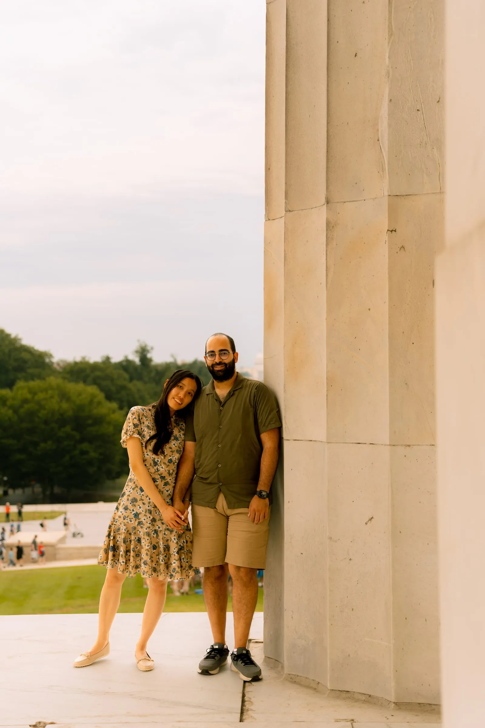 Maryann and Samuel leaning against a column at the Lincoln Memorial, smiling at the camera