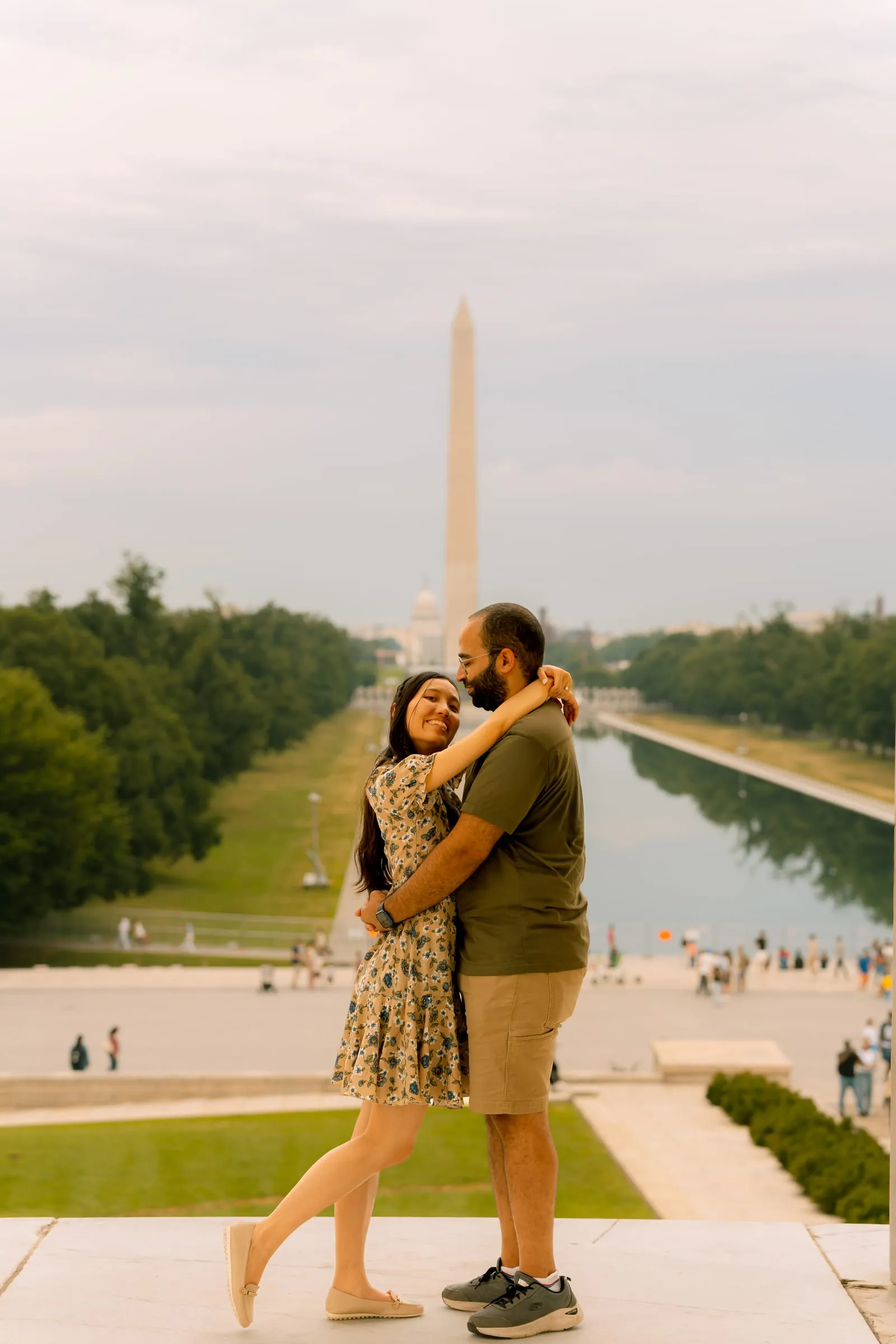 Maryann and Samuel embracing in front of the Washington Monument and Reflecting Pool