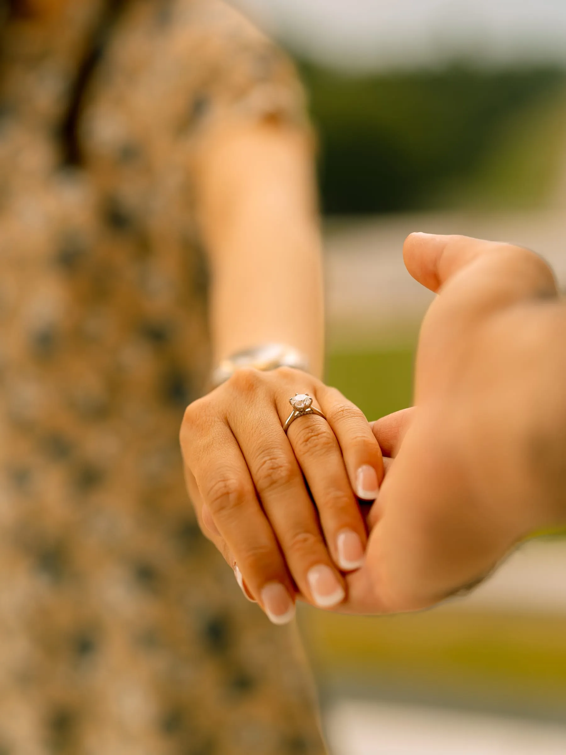 Detail of Maryann and Samuel's clasped hands showing her engagement ring