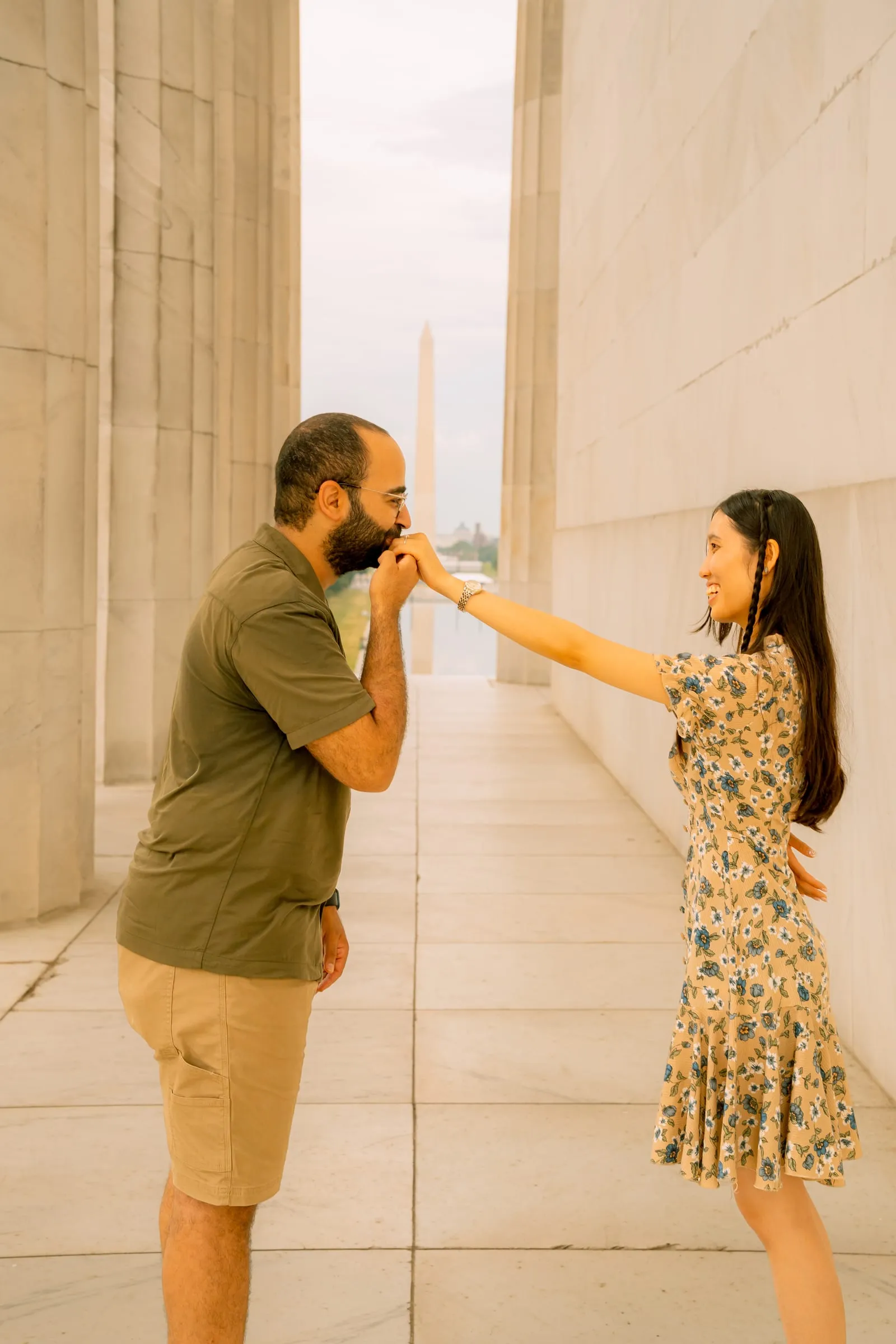 Samuel kissing Maryann's hand as she reaches out to him between the columns