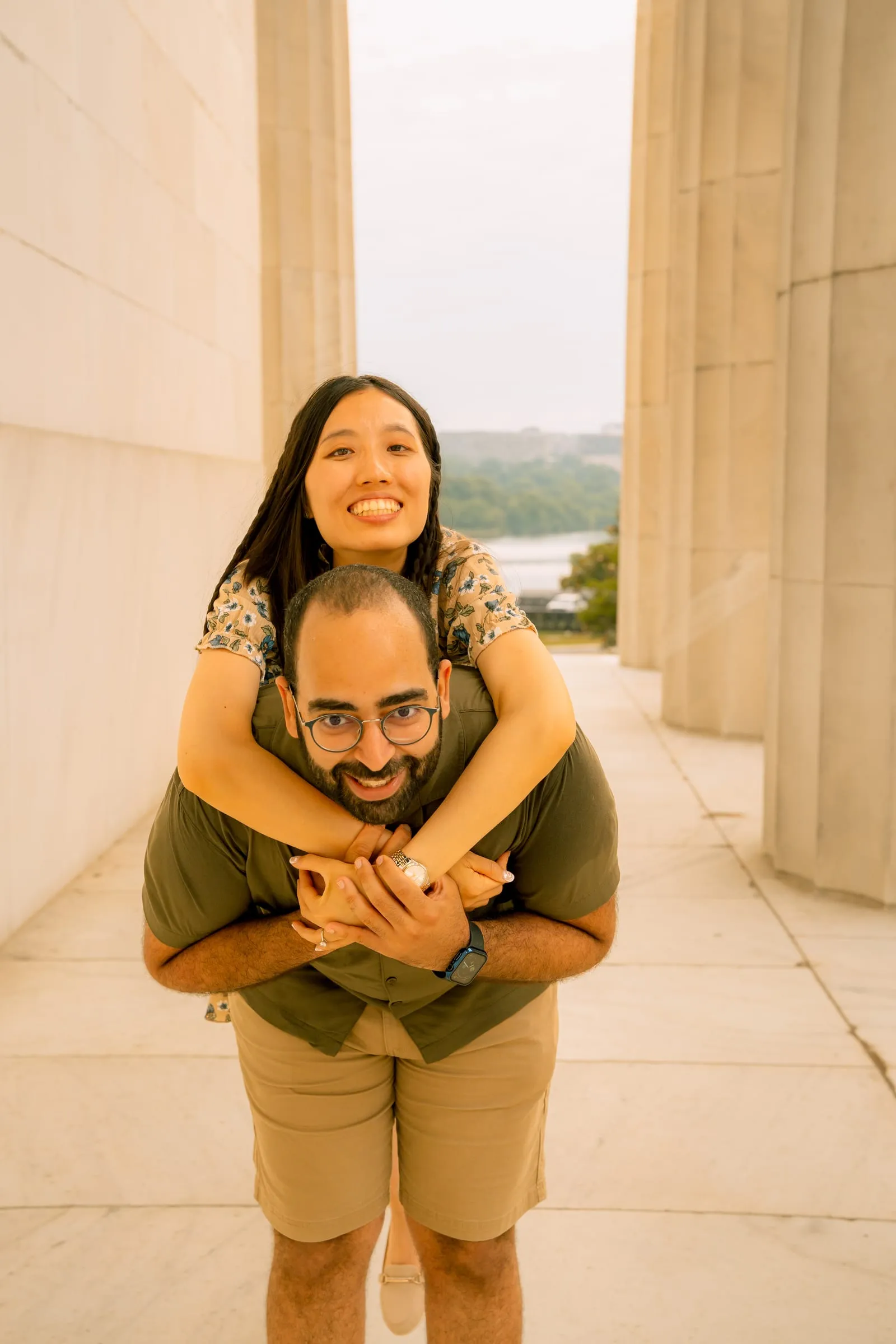 Maryann laughing on Samuel's back as he carries her, the Potomac visible behind them