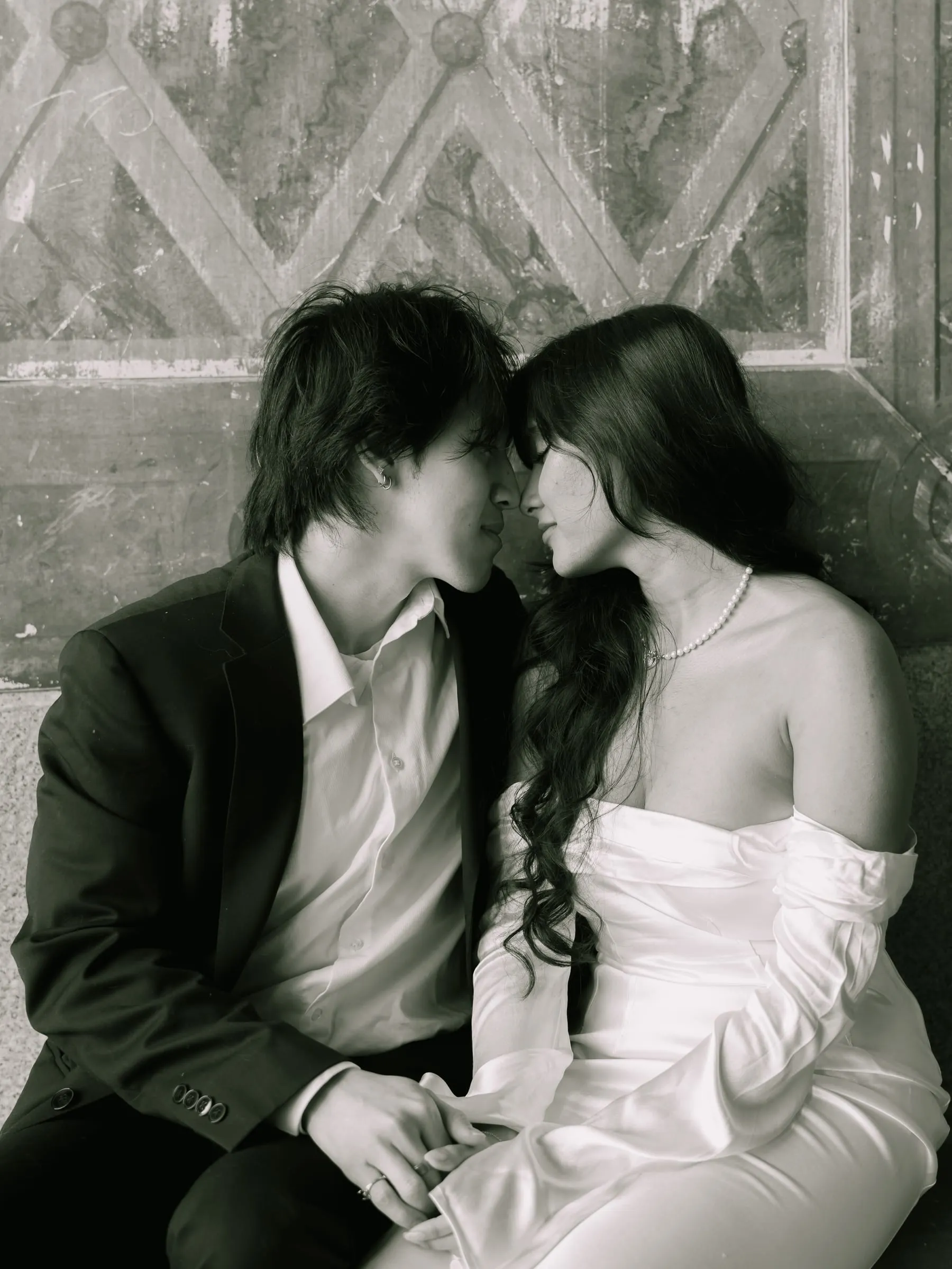 Black and white portrait of Noushin and Nathan foreheads together at Bethesda Terrace