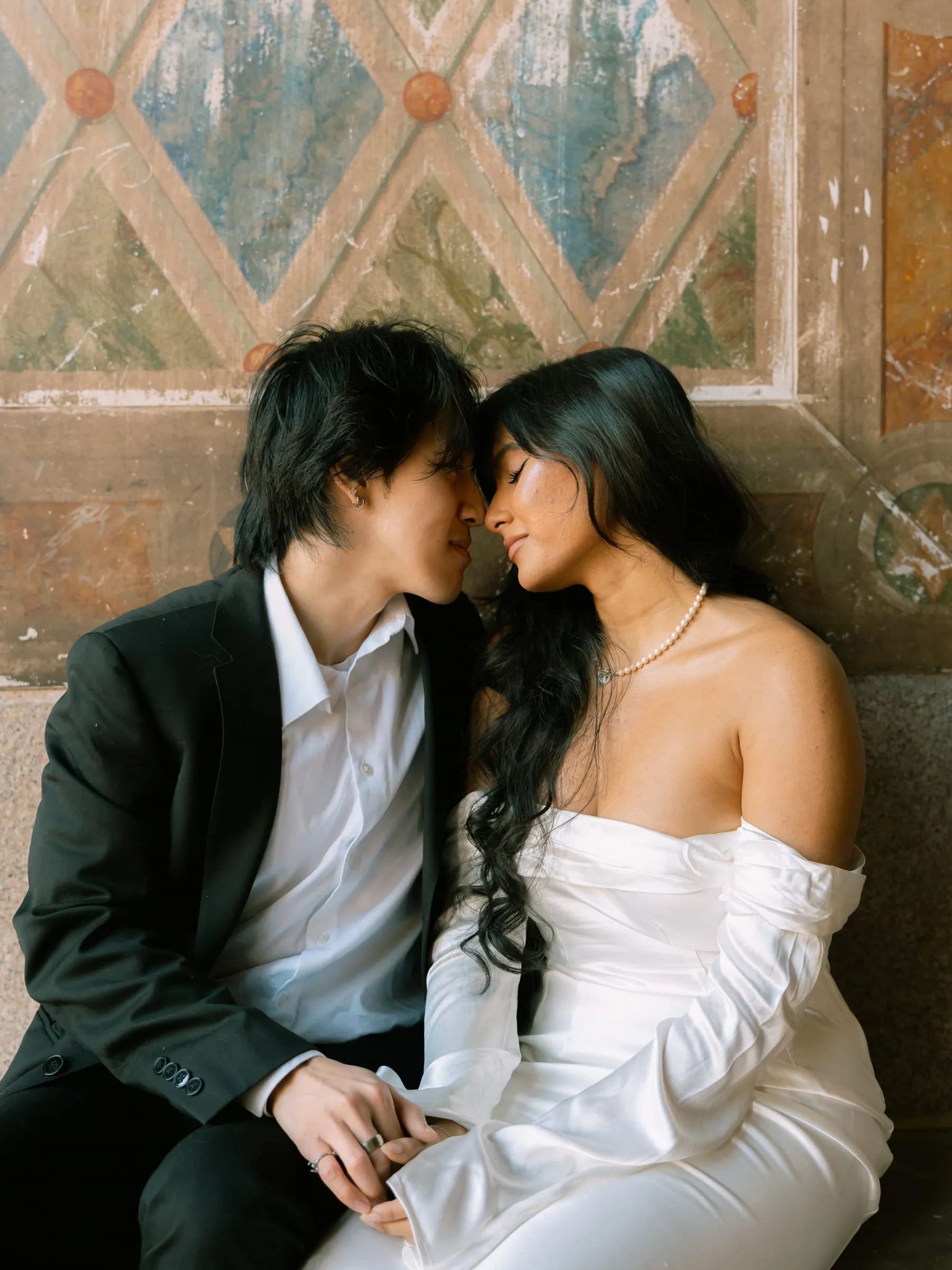 Noushin and Nathan seated nose to nose beneath the painted panel of Bethesda Terrace