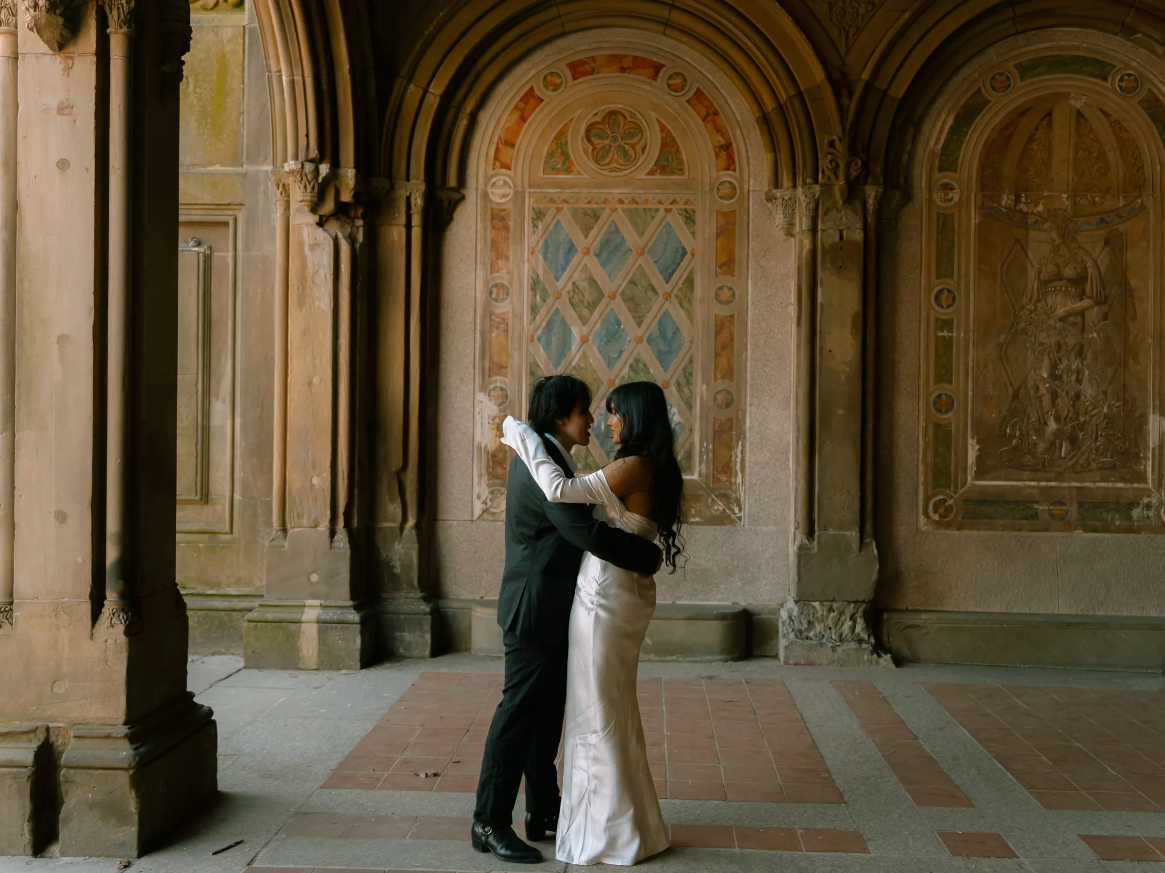 Noushin and Nathan embracing in the middle of the Bethesda Terrace arcade