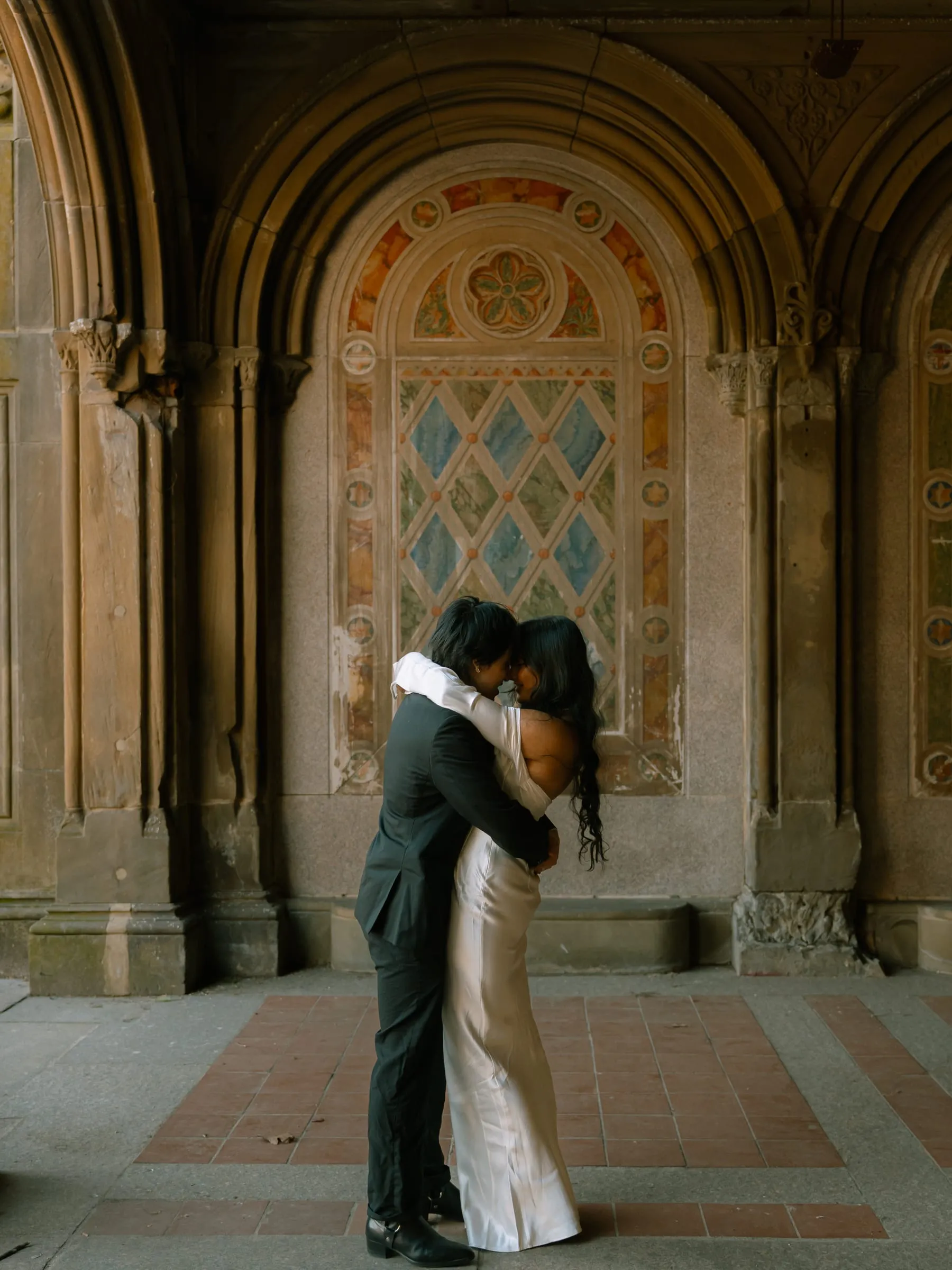 Noushin and Nathan holding each other close beneath the painted lattice panel