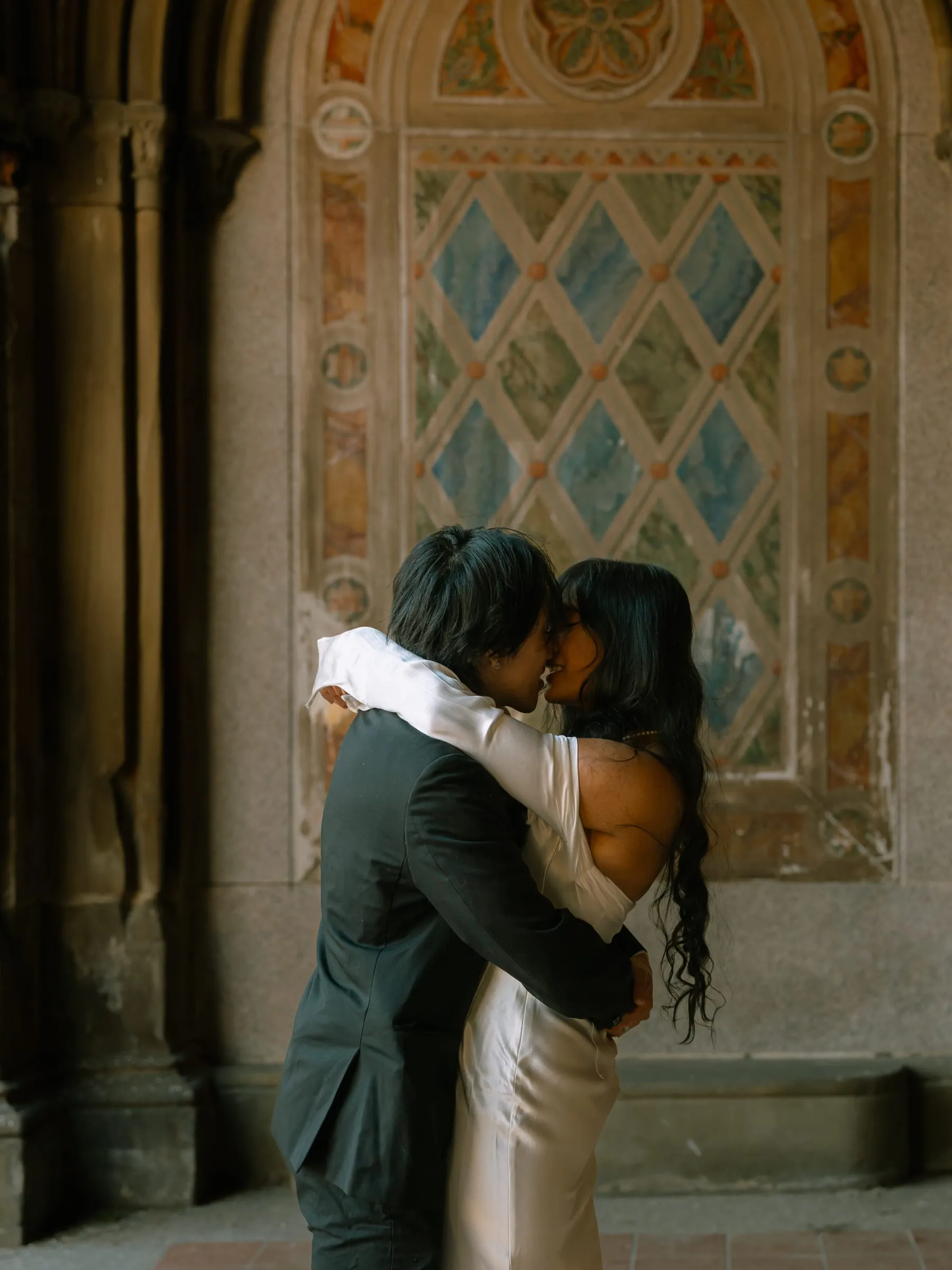 Noushin and Nathan sharing a kiss beneath the painted lattice panel