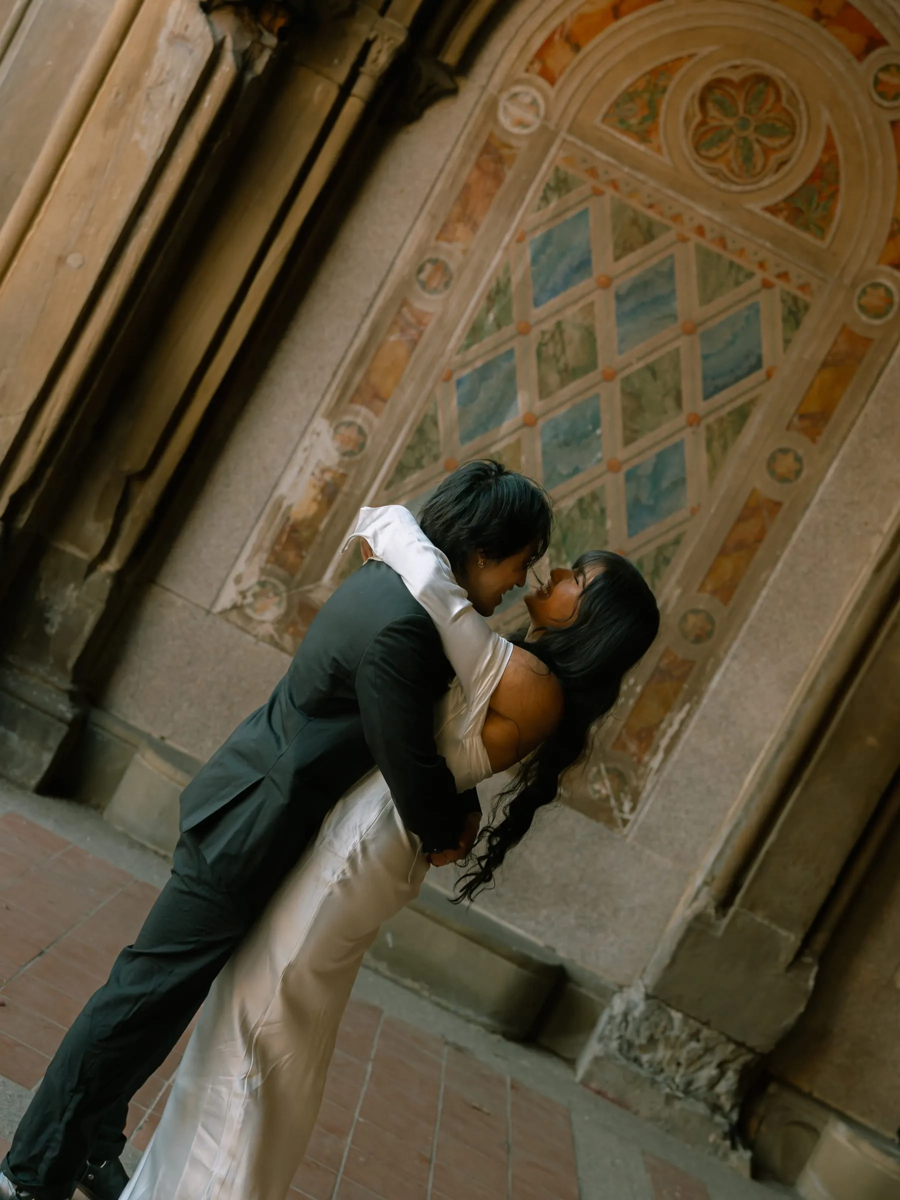 Nathan dipping Noushin for a kiss beneath the ornate stonework of Bethesda Terrace