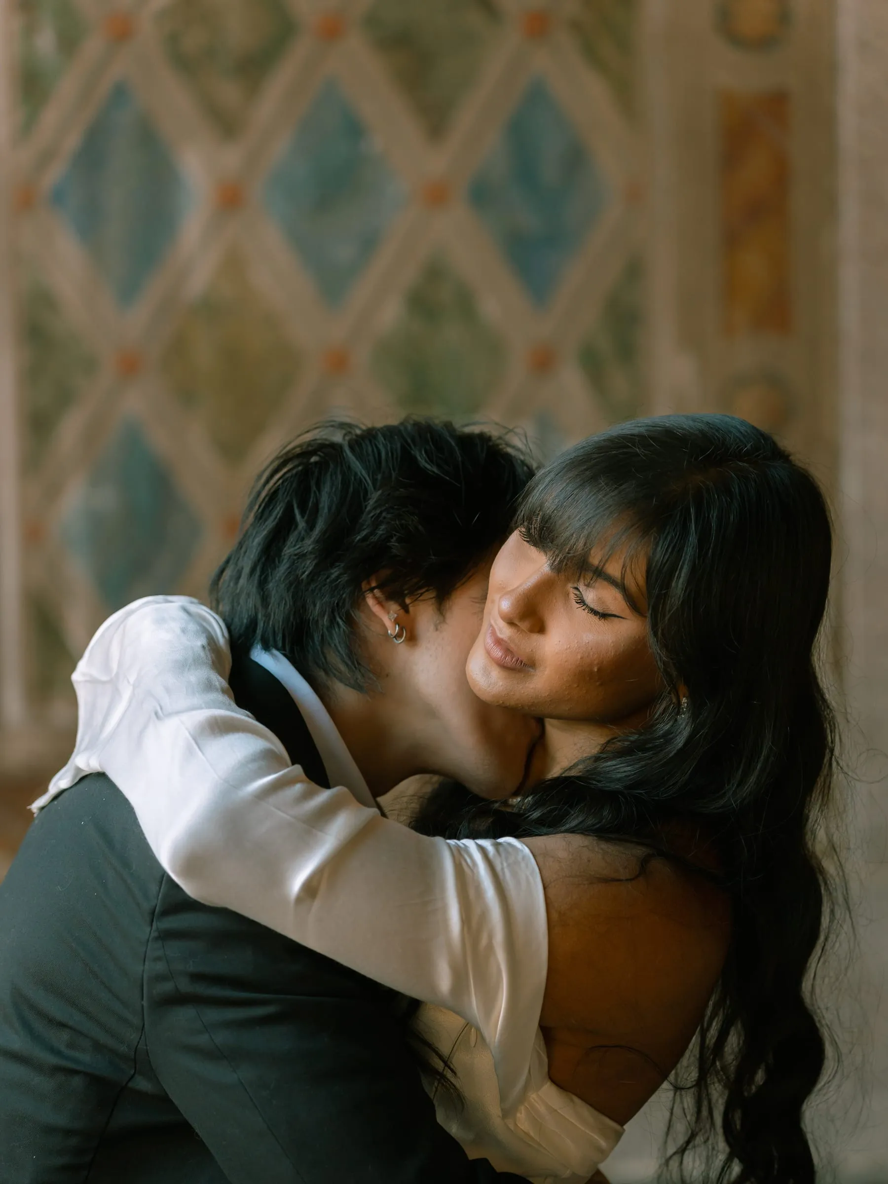 A close embrace, Nathan's face pressed to Noushin's cheek as she closes her eyes