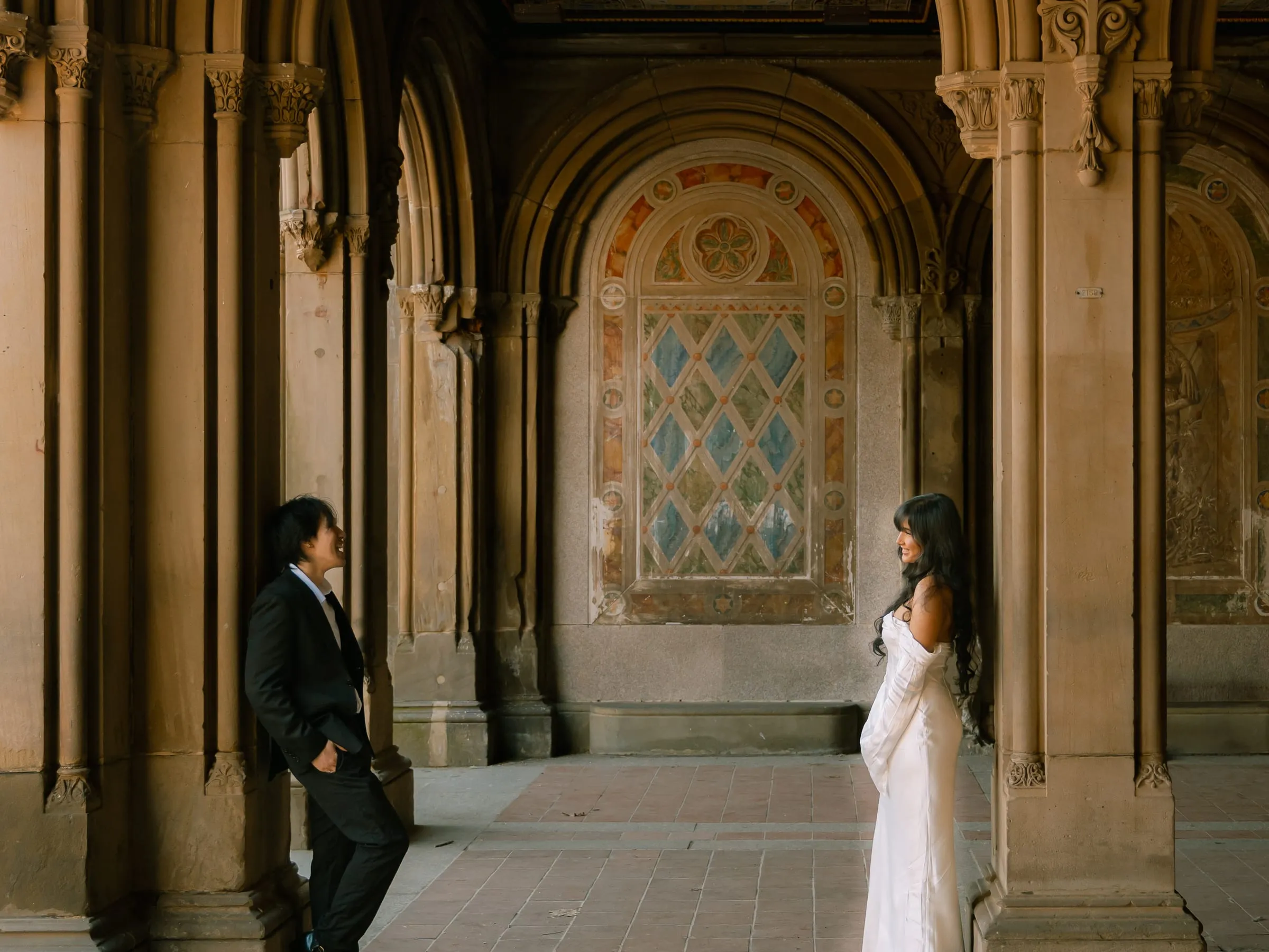 Noushin and Nathan laughing at each other from across the arches of Bethesda Terrace