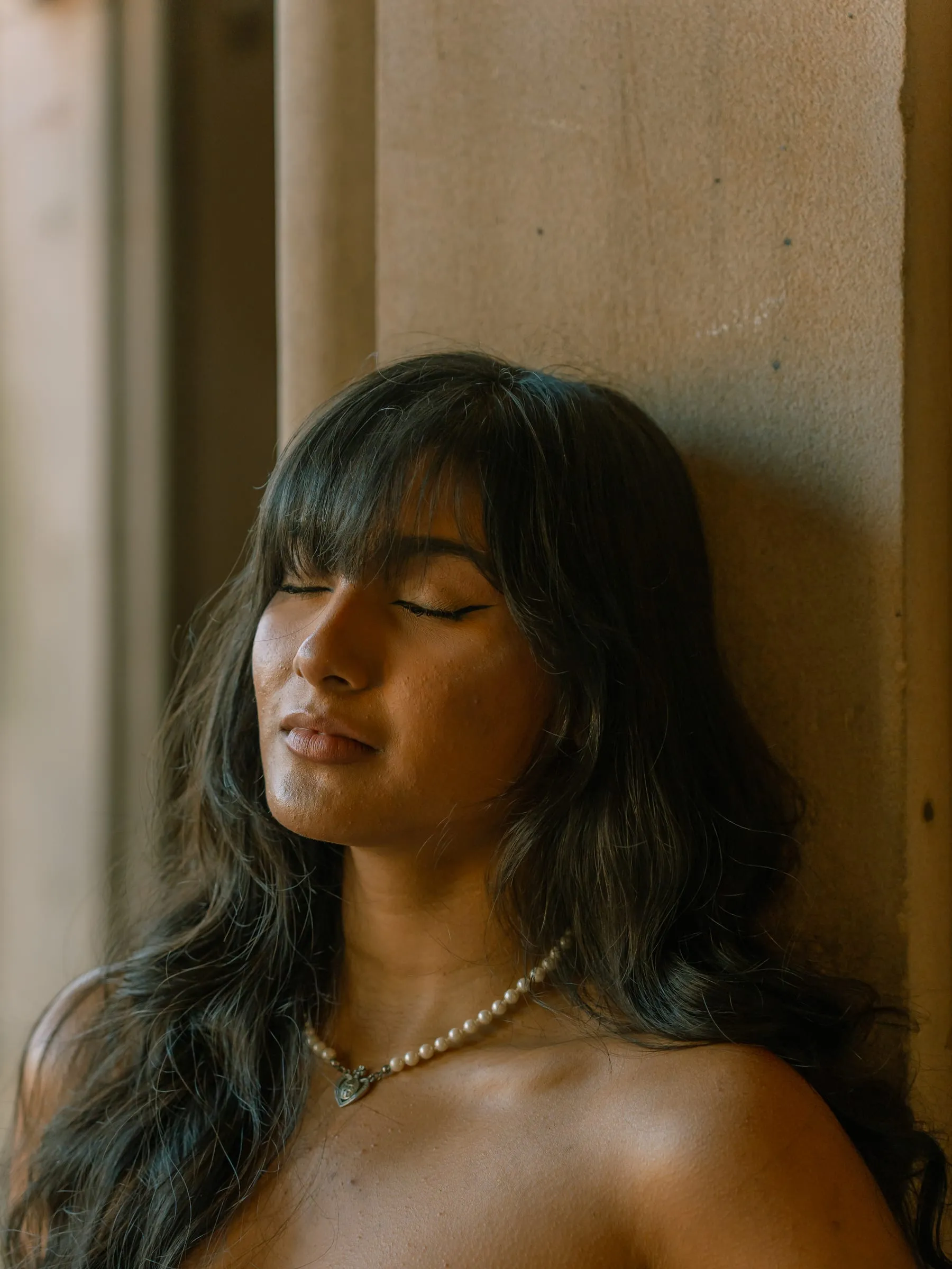A close-up portrait of Noushin with her eyes closed in the afternoon light