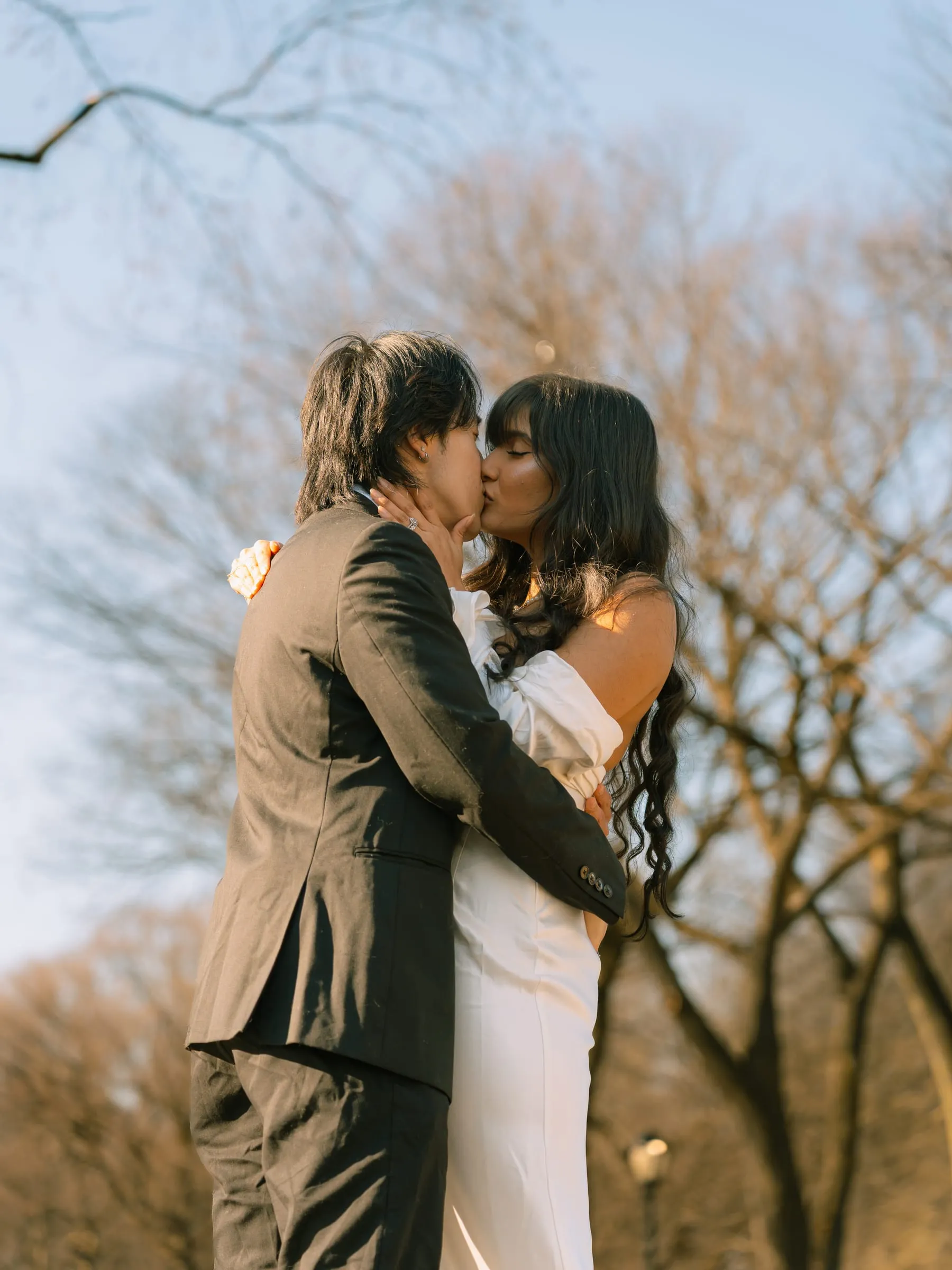 Noushin and Nathan sharing a kiss in the golden late-afternoon light