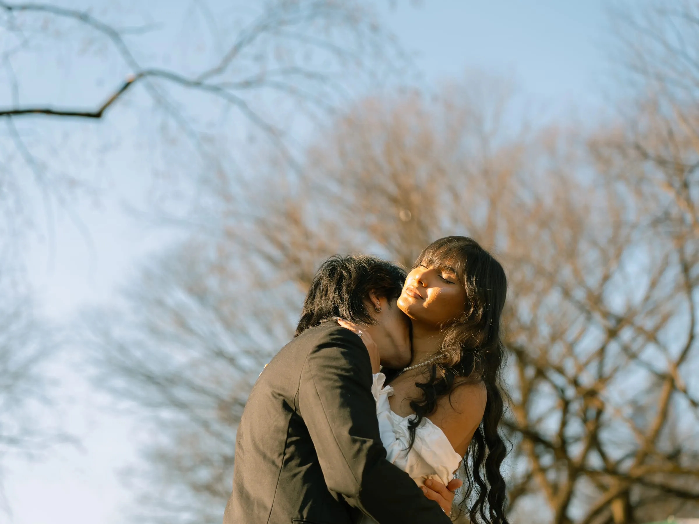 Noushin and Nathan cheek to cheek in the warm evening light among the trees