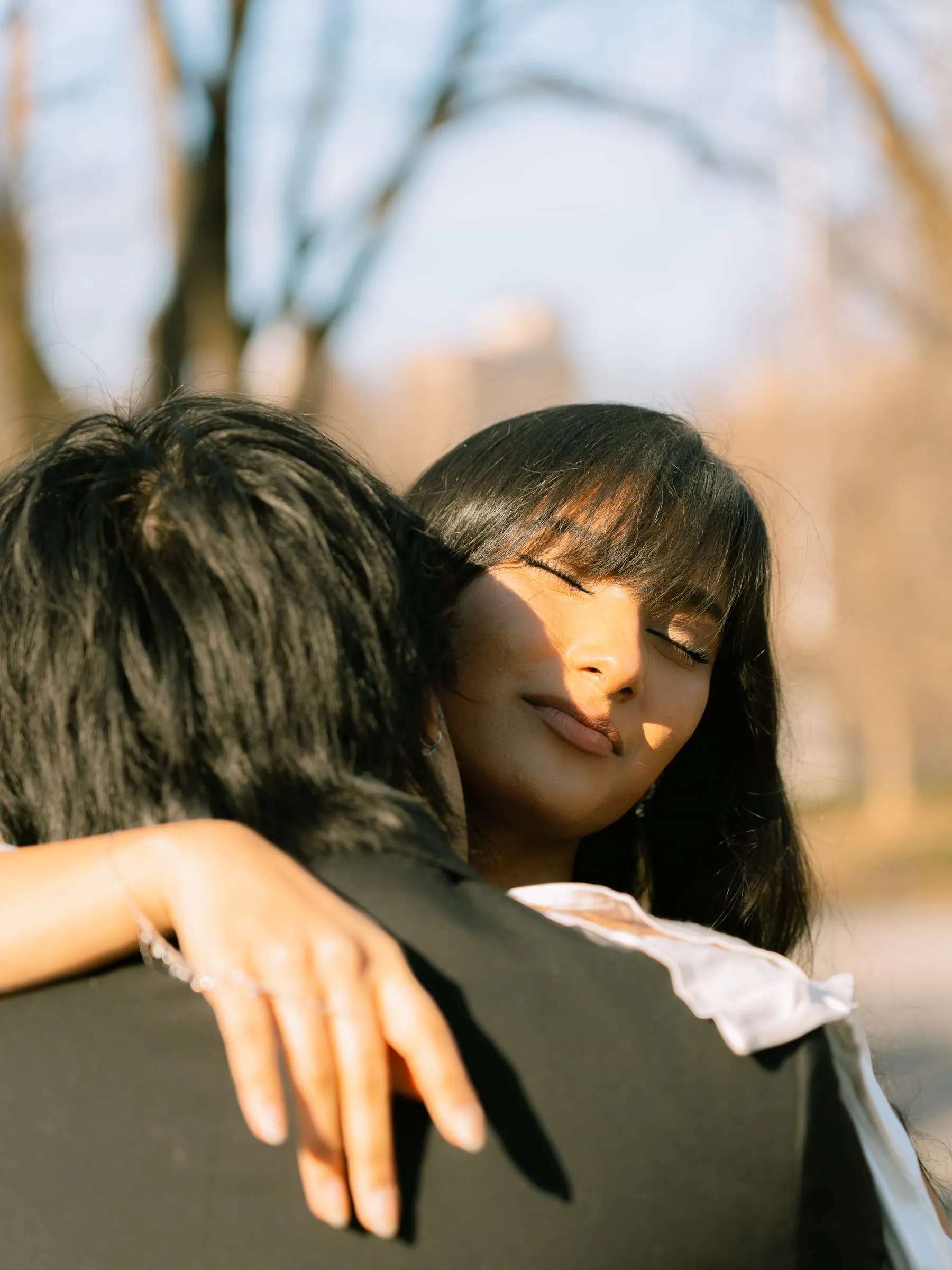 A quiet embrace between Noushin and Nathan lit by the setting sun