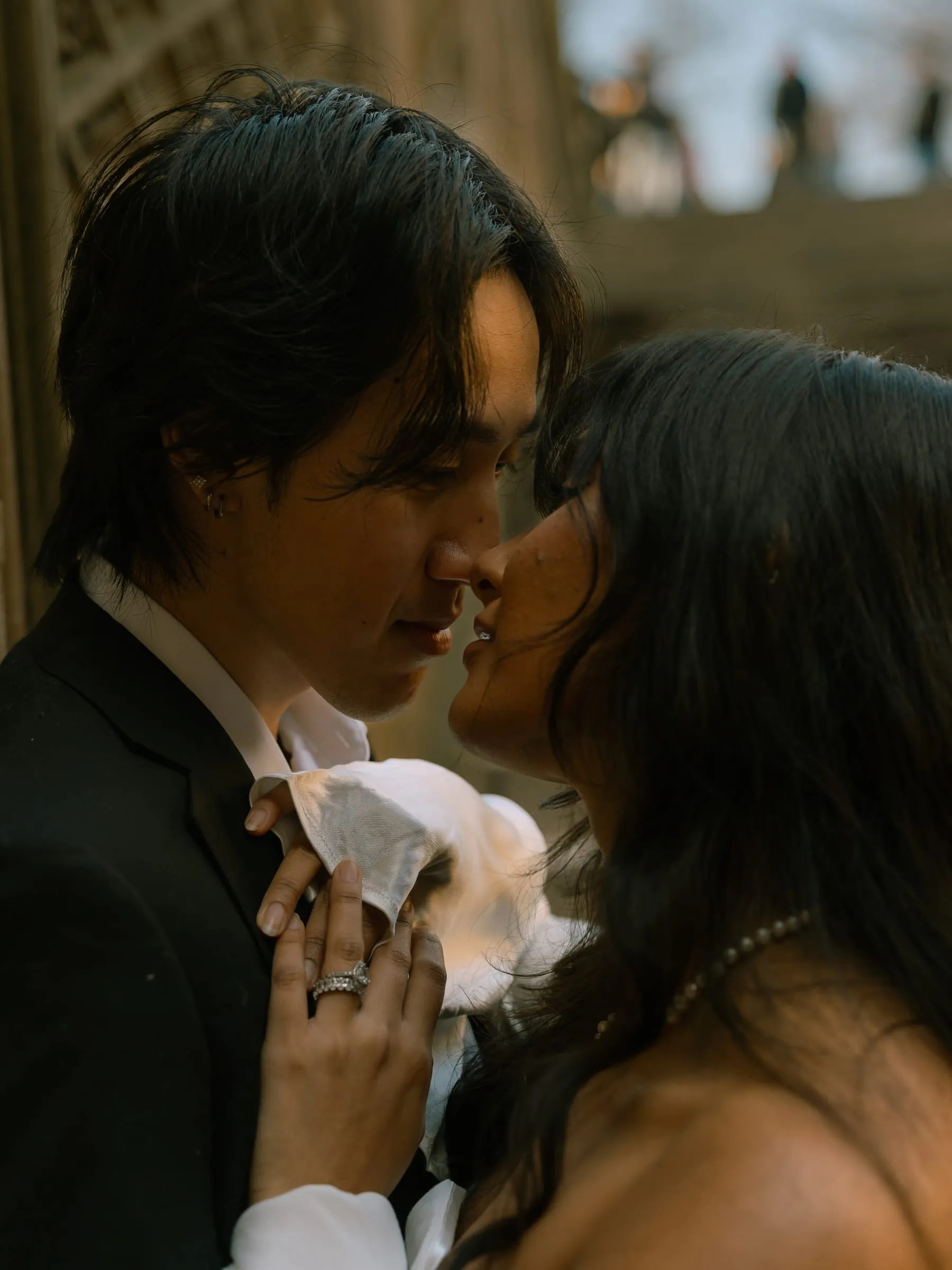 A close-up of Noushin and Nathan nose to nose, her hand resting on his chest