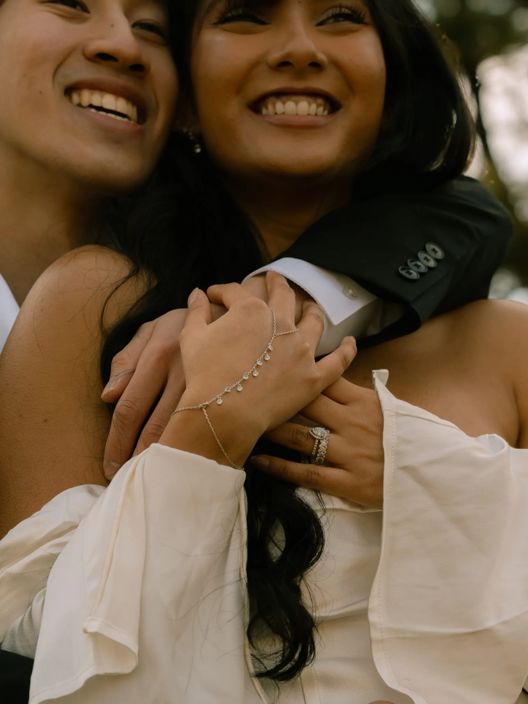 A close-up of Noushin and Nathan's hands together, Noushin's ring and bracelet catching the light