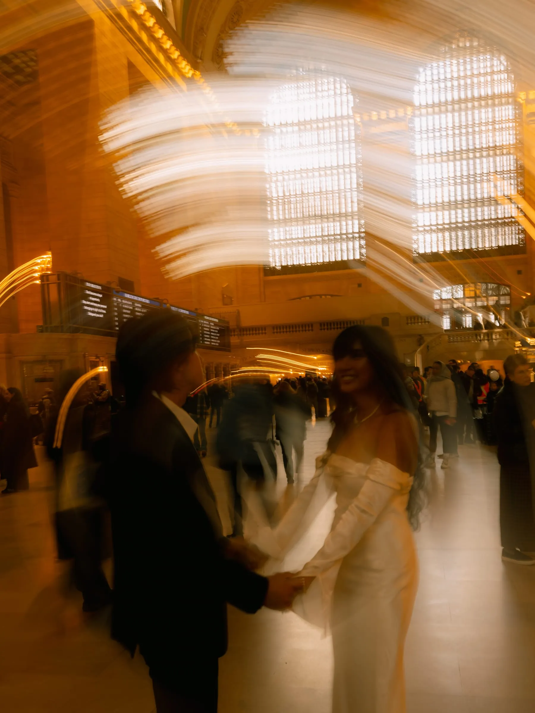 A long-exposure view of Noushin and Nathan beneath Grand Central Terminal's grand arched windows