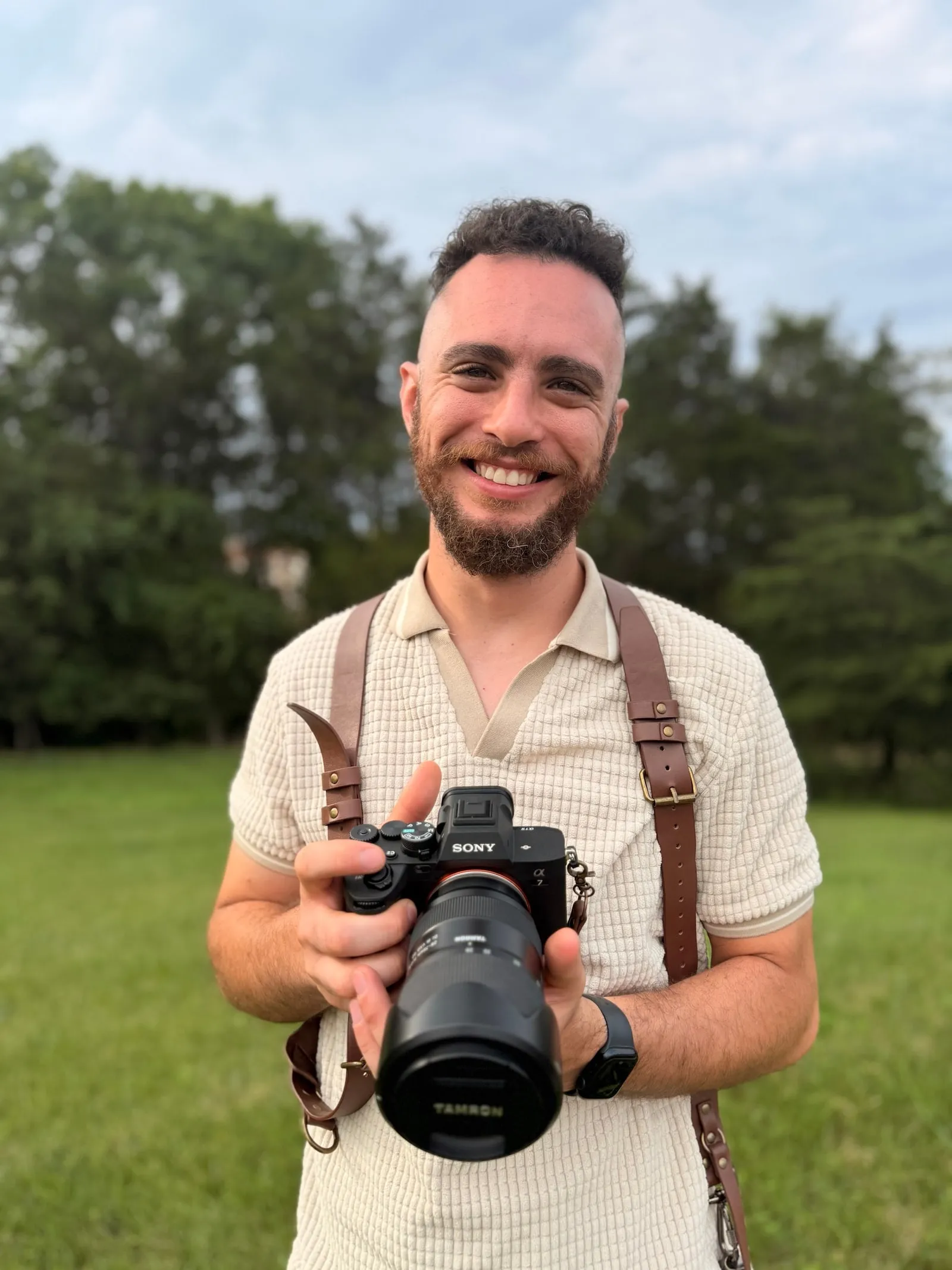 Raphael, the photographer behind Raphi's Edits, holding a camera