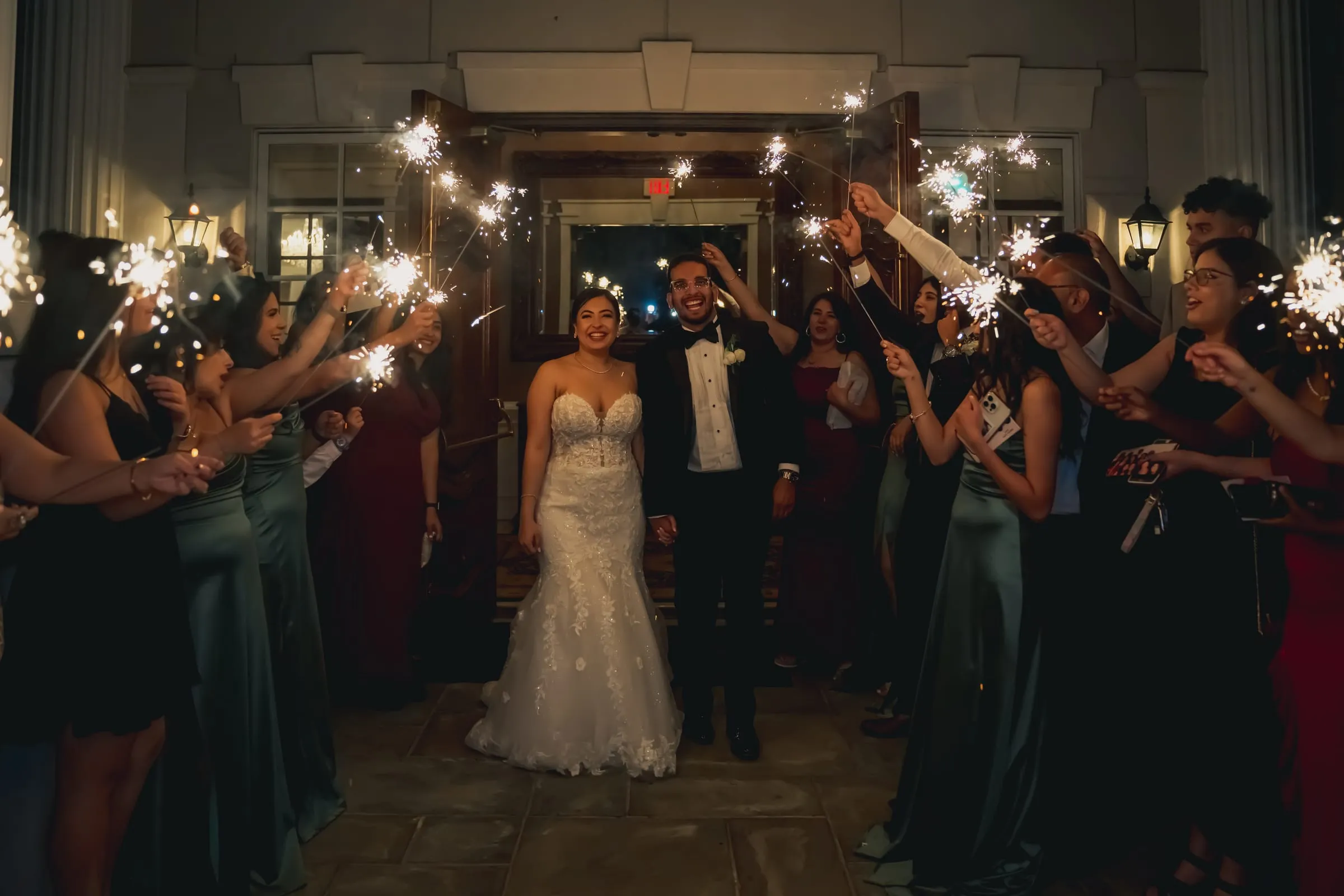 Sandy and Steph walking arm in arm through a glowing tunnel of sparklers