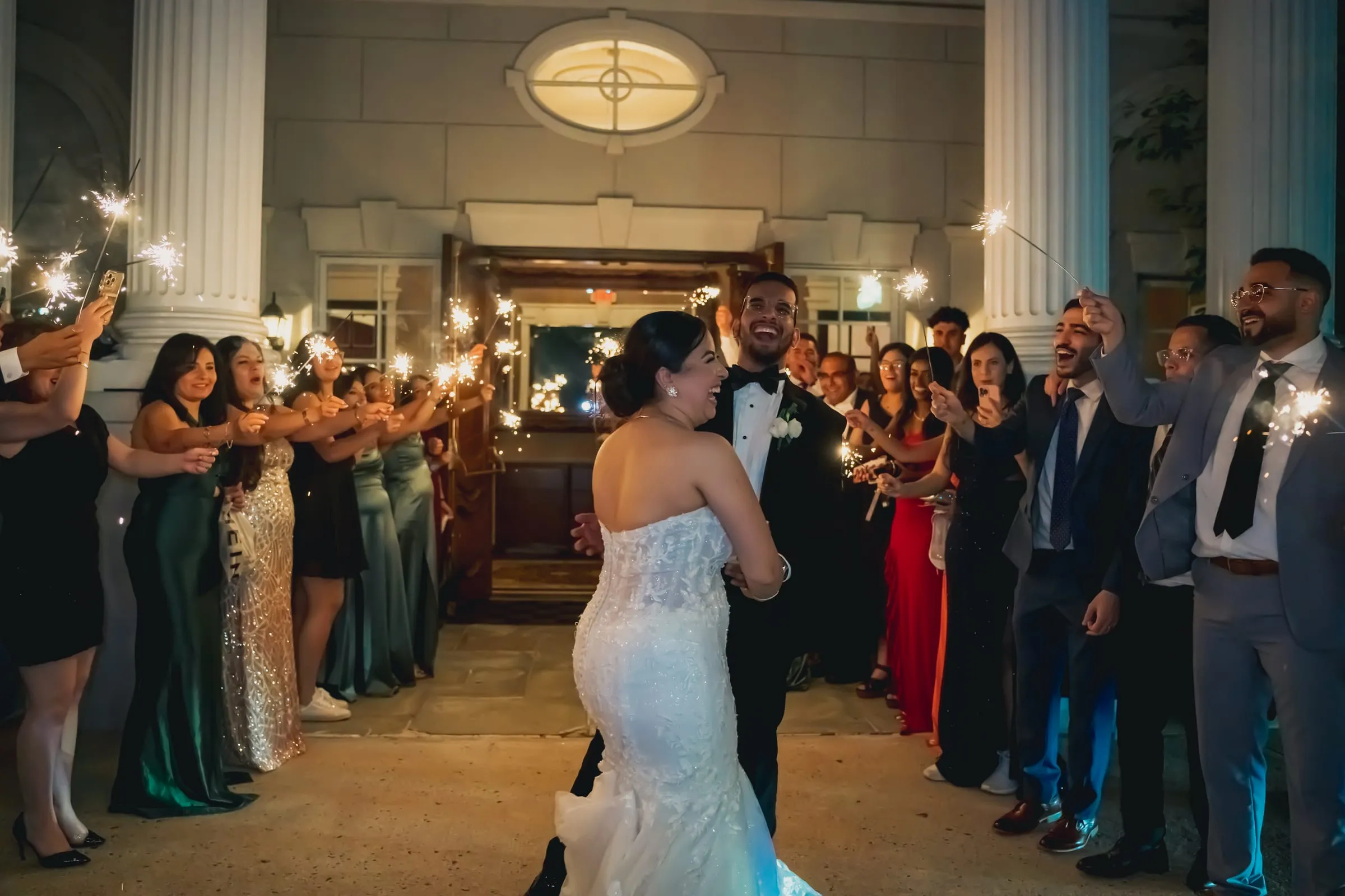 Sandy and Steph dancing close and laughing as guests film on their phones