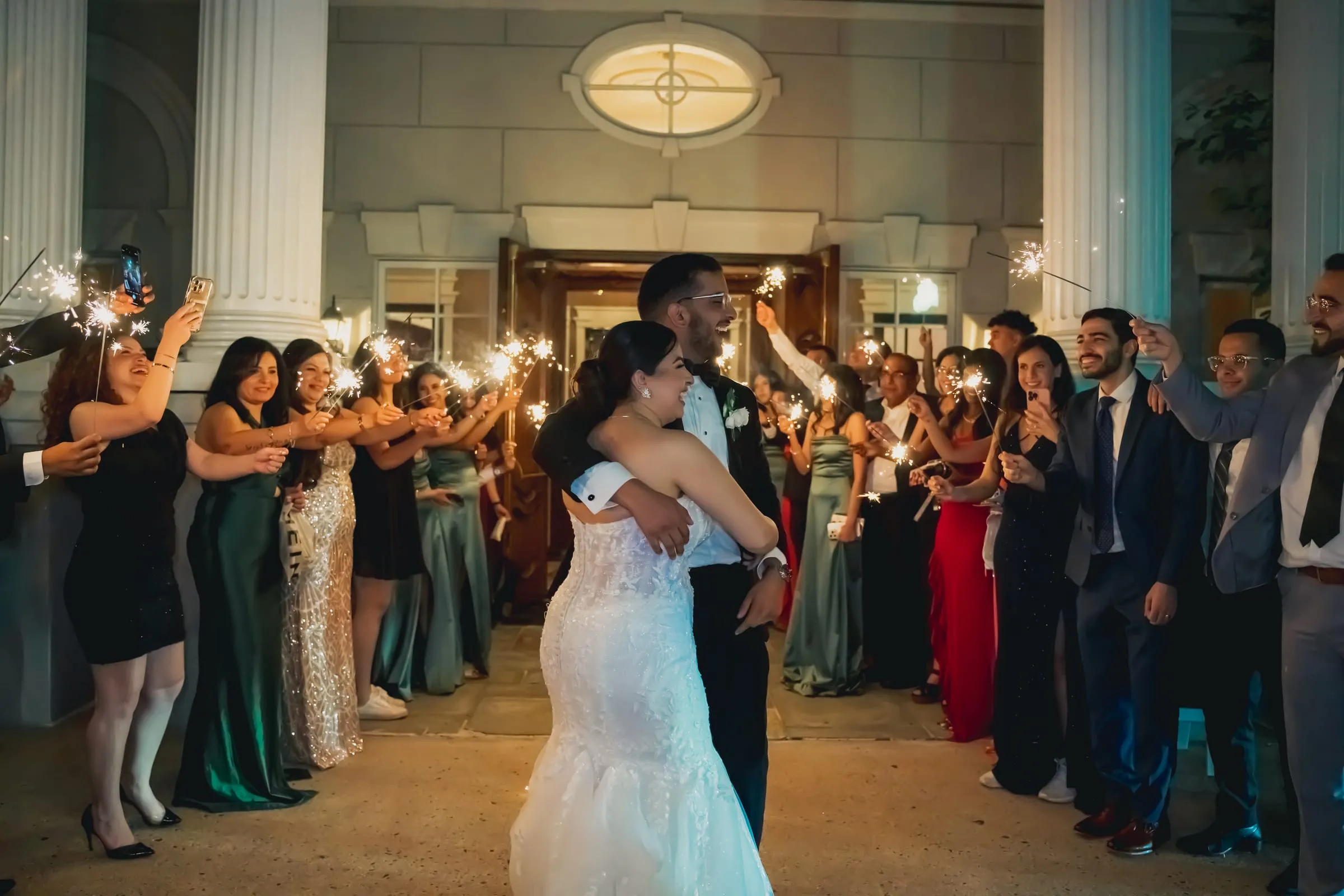 Sandy and Steph embracing in the middle of the sparkler tunnel